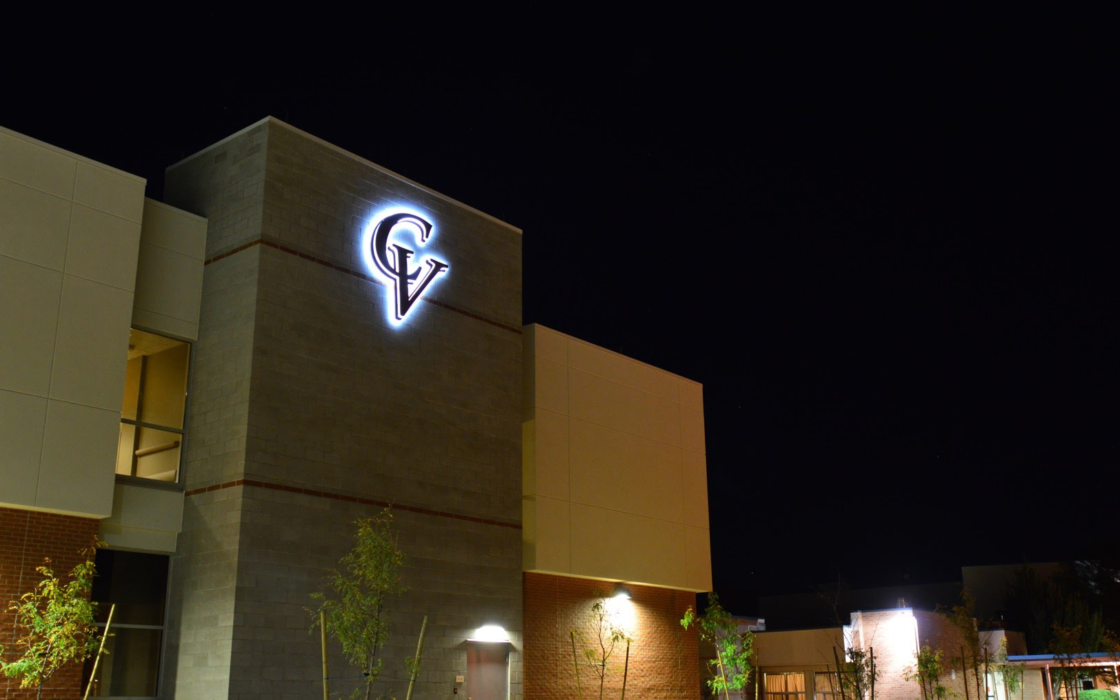 Nighttime exterior view of an illuminated Cobre Valley Regional Medical Center logo on the building tower