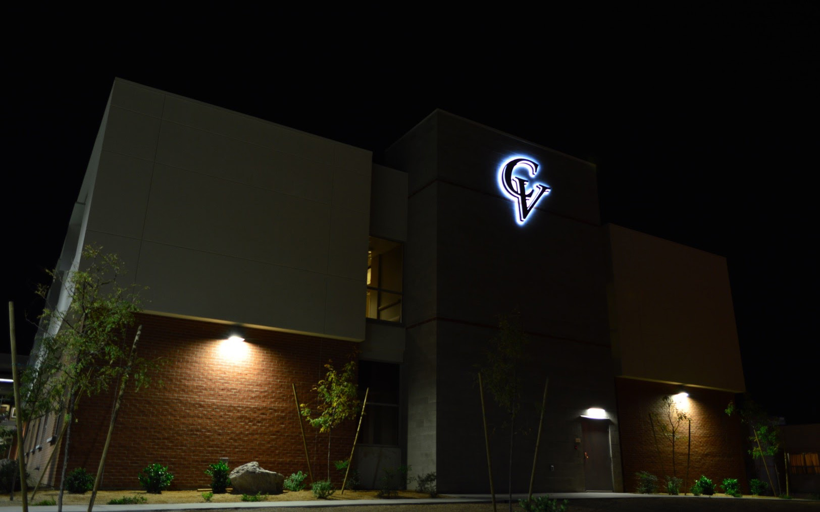 Wide nighttime view of the Cobre Valley Regional Medical Center building with an illuminated logo
