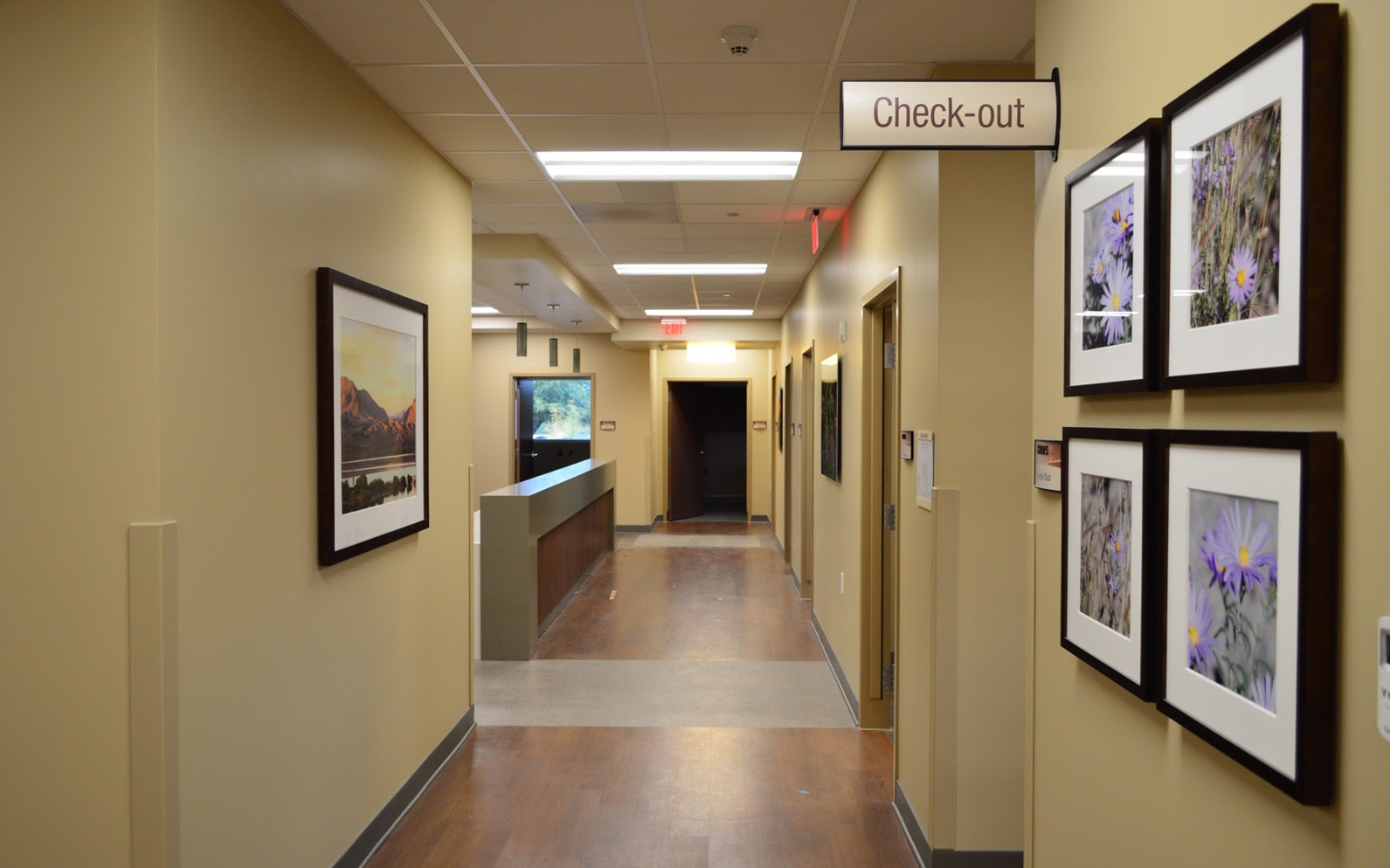 Double-sided projecting flag sign identifying the patient check-out area in a hospital corridor