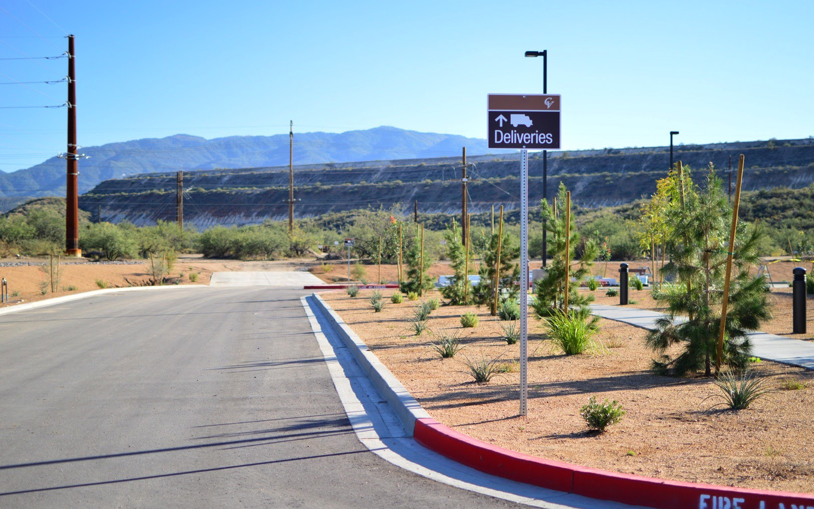 Exterior post-mounted directional sign with truck symbol and arrow guiding delivery vehicles