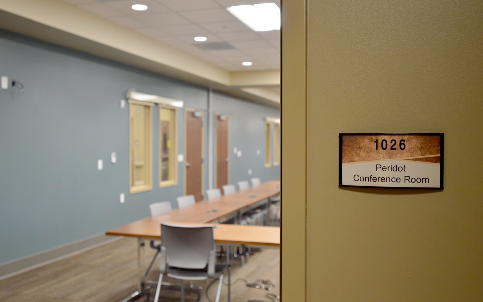 ADA-compliant sign identifying room 1026 as the Peridot Conference Room at the medical center