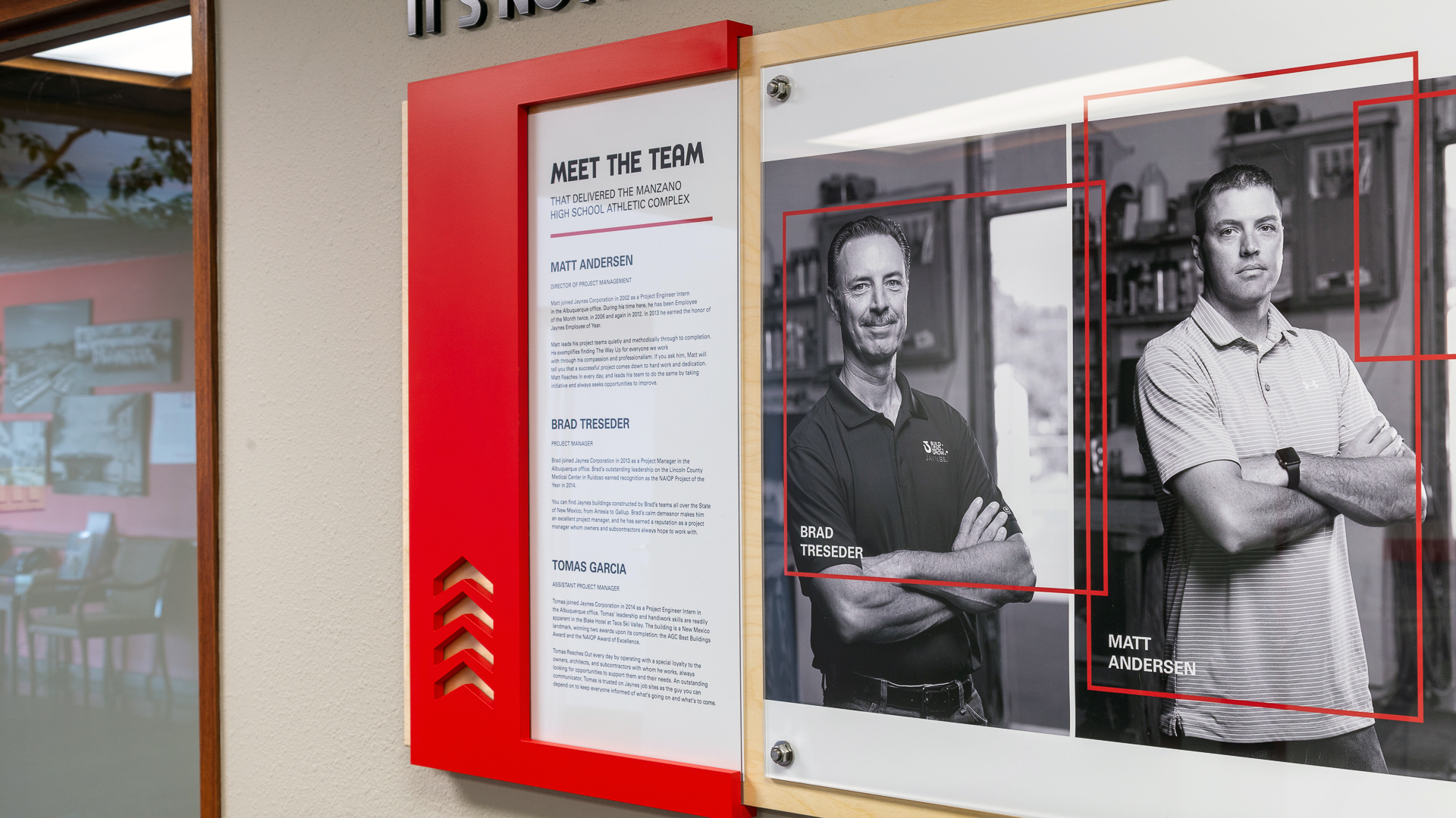 Front view of corporate branding display wall with project team graphics and stand-off mounted panels
