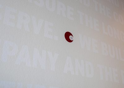 Close up detail of updateable signage system on wow wall showing interchangeable panels at Caliente Construction office