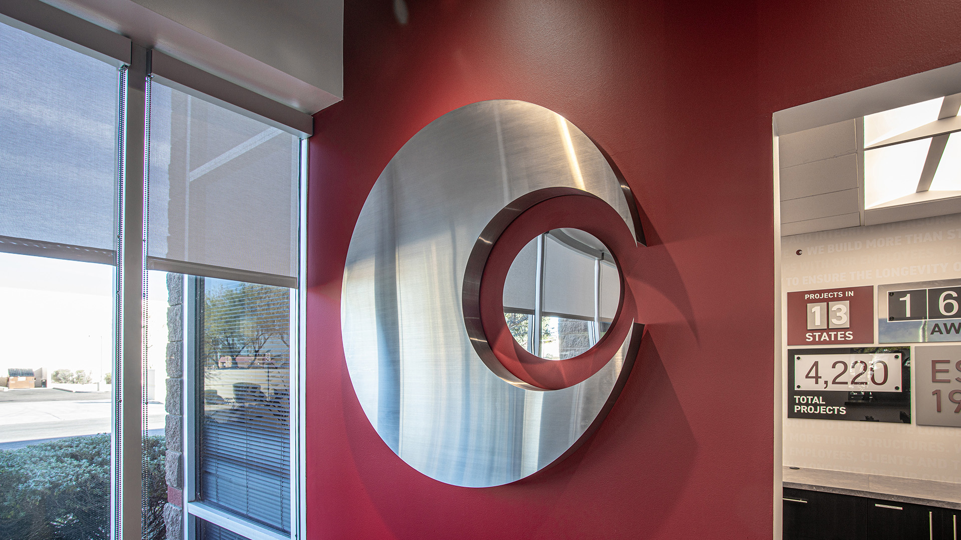 Reception area featuring branded wow wall display with company milestones at Caliente Construction office in Phoenix Arizona