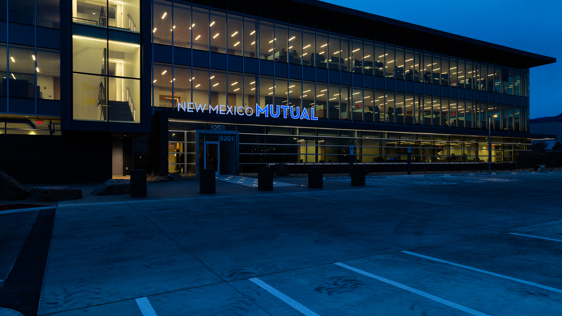 Exterior signage at night showing front face lit channel letters on corporate building New Mexico Mutual Albuquerque