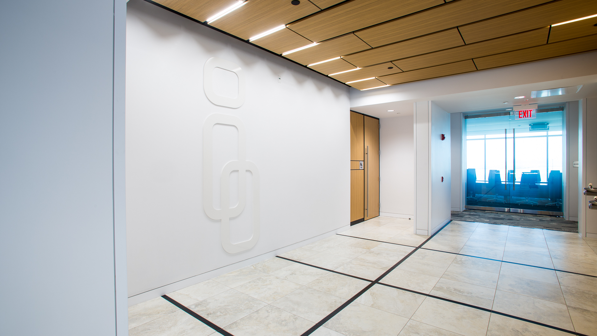 Large flat cut dimensional logo mounted on white wall at elevator lobby landing New Mexico Mutual Albuquerque