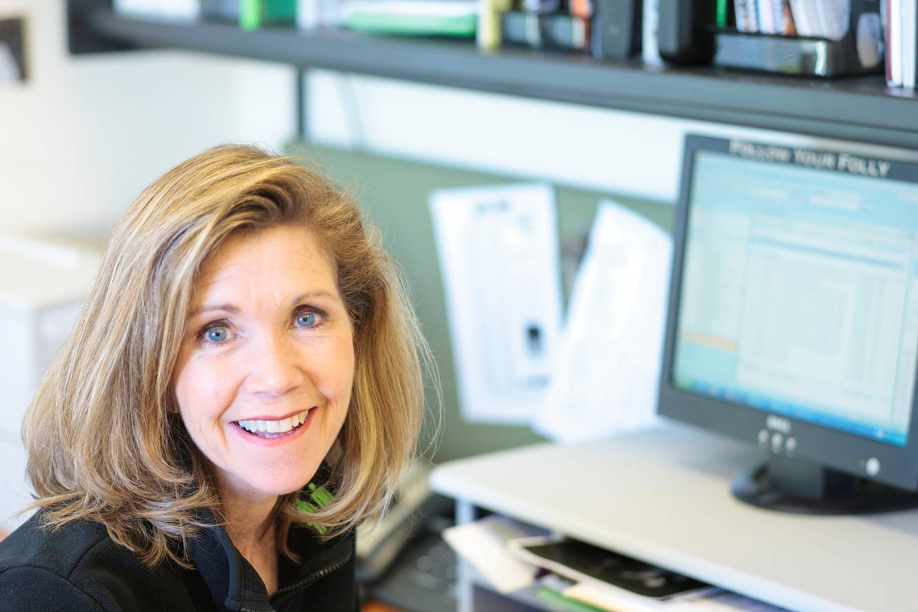 Headshot of a woman sitting next to her computer wearing black shirt