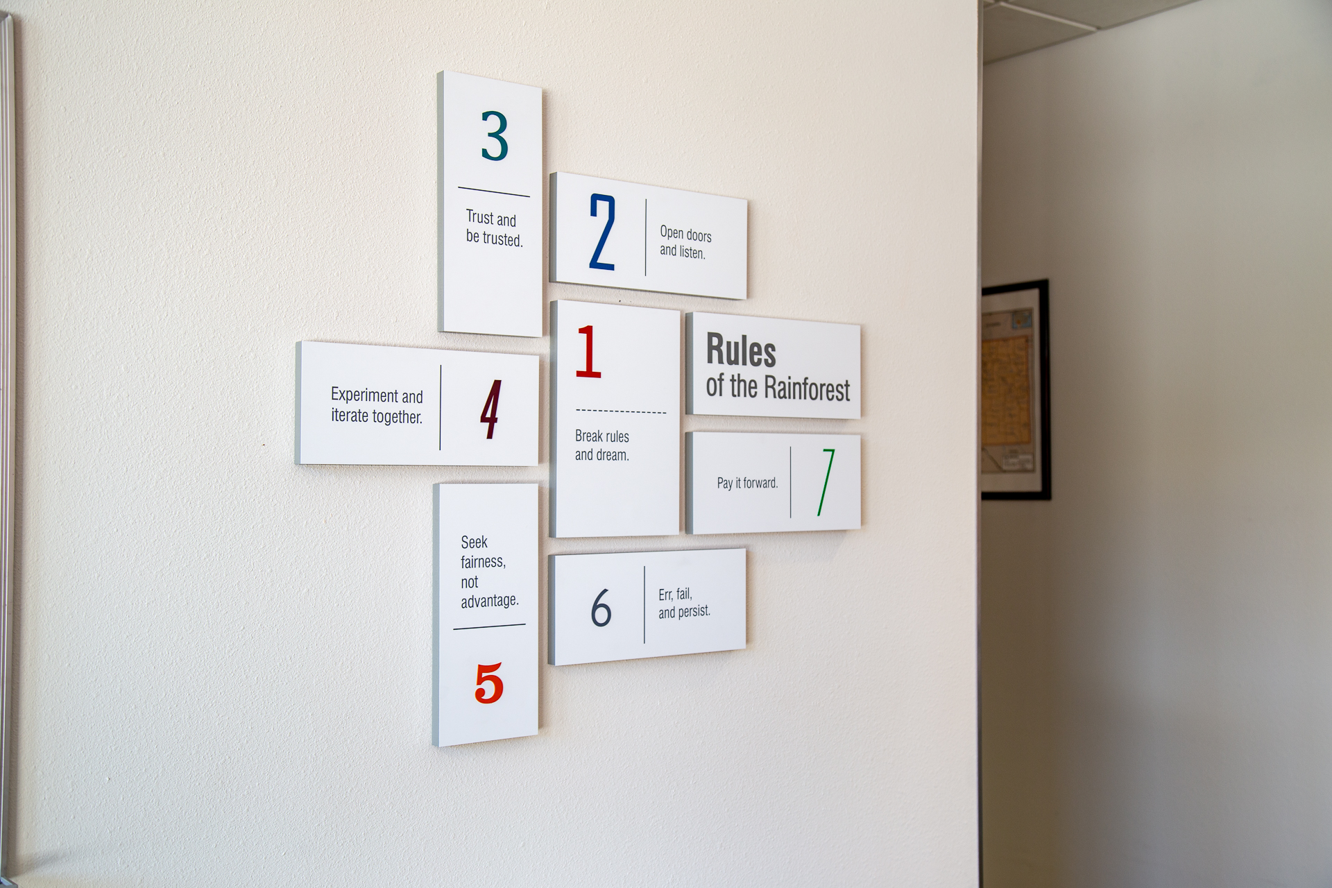 Interior branded signage display at UNM Lobo Rainforest featuring Rules of the Rainforest with multi-panel typography layout