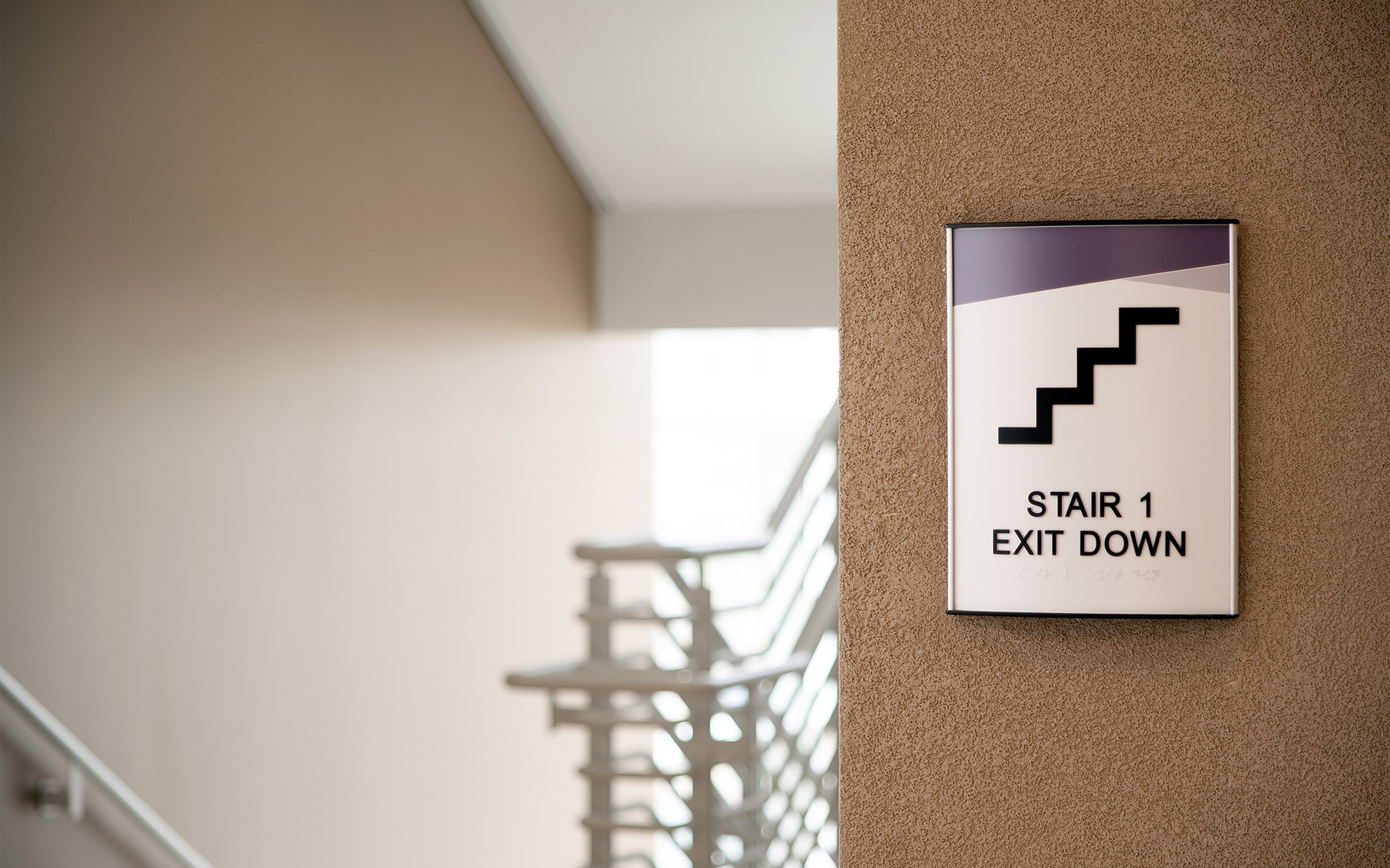 ADA stair identification sign with exit down direction at UNM Sandoval Regional Medical Center