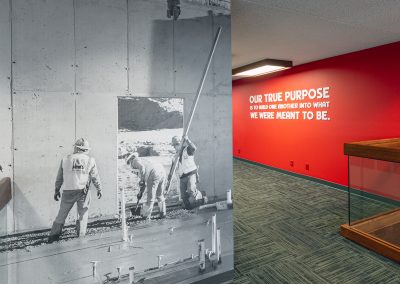 Corporate interior wall featuring custom black and white wallpaper graphic and dimensional flat cut lettering on red accent wall