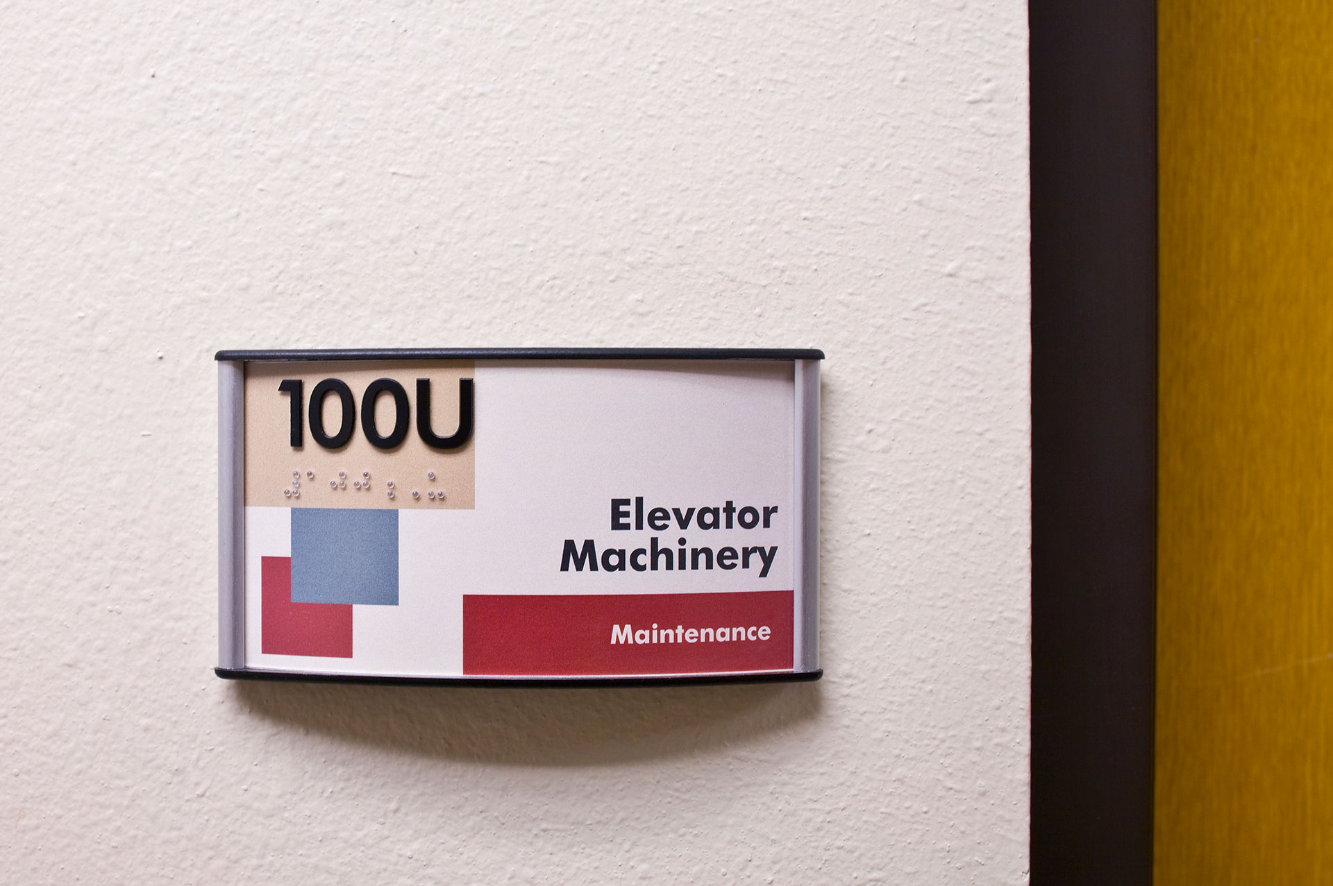 ADA compliant room identification sign with tactile lettering and braille using Diversity Sign System