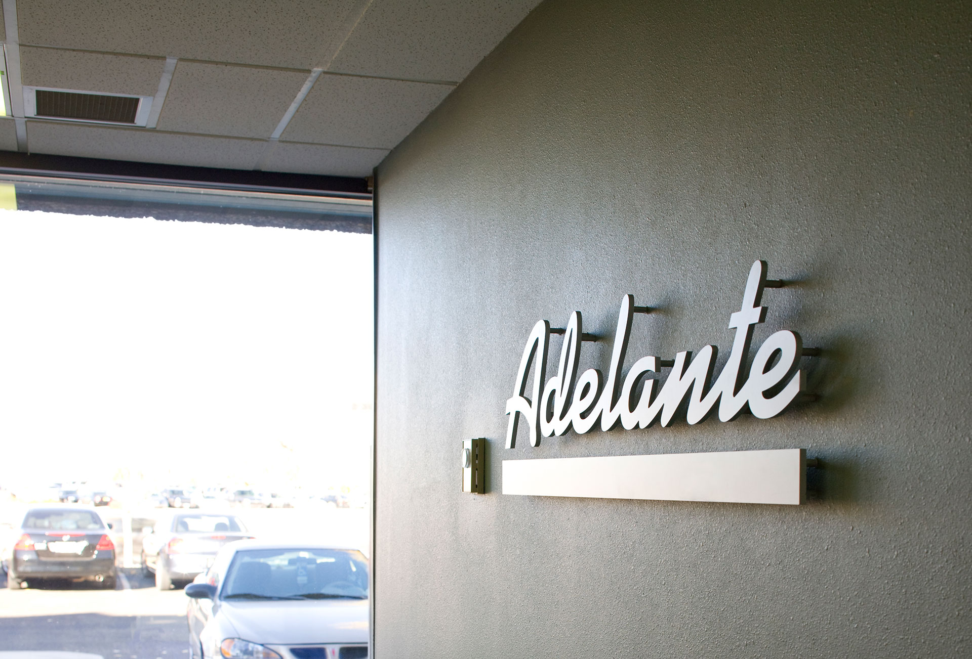 Interior wall signage with flat cut acrylic dimensional letters mounted to painted surface