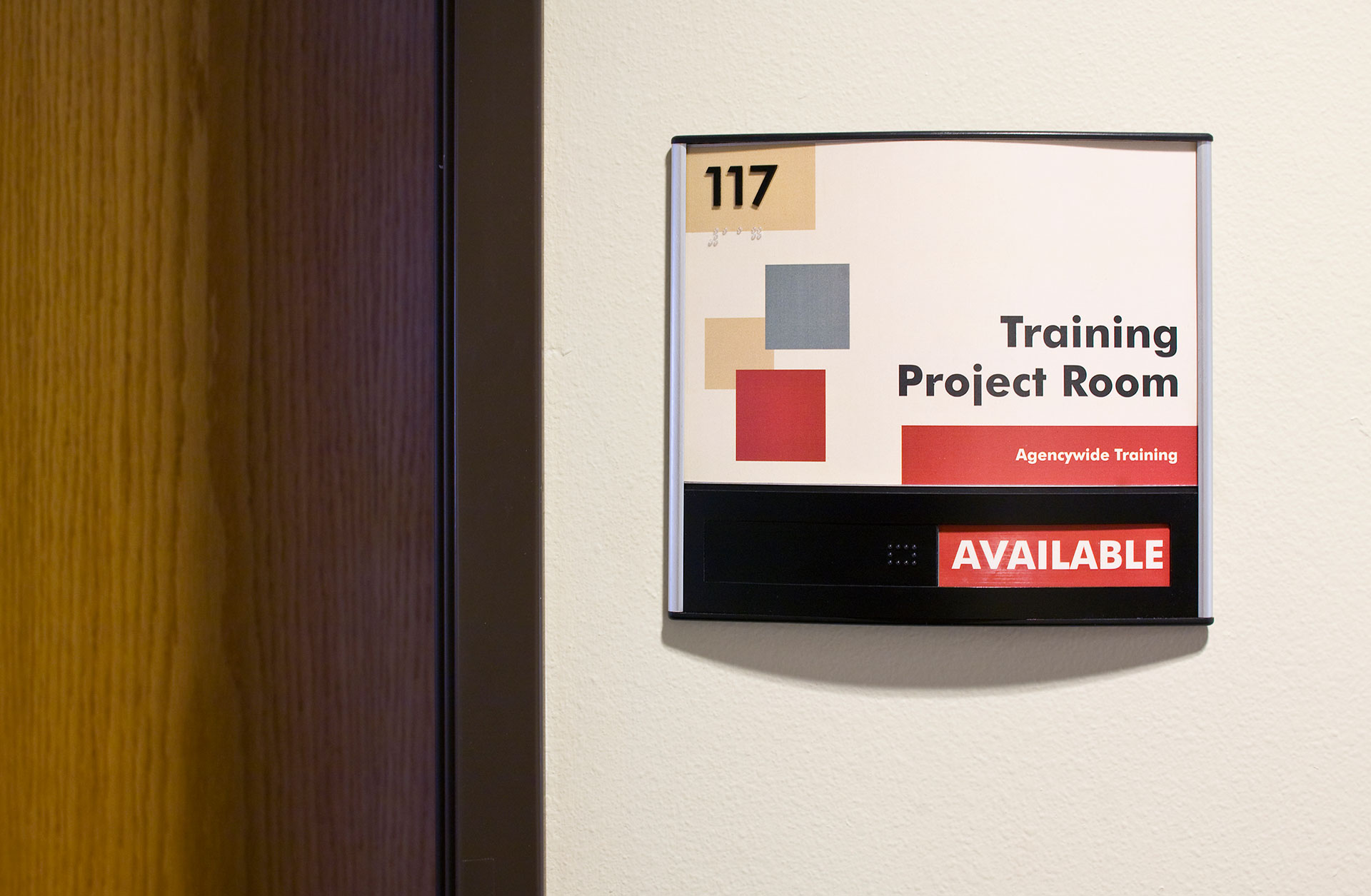 ADA room sign with slider indicating available or in-use status for training room