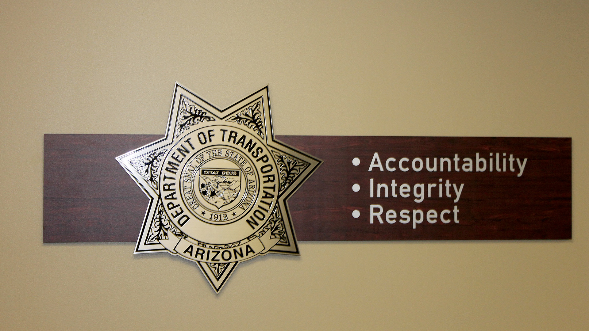 Etched stainless steel plaque displaying ADOT mission statement with blind stud mounting