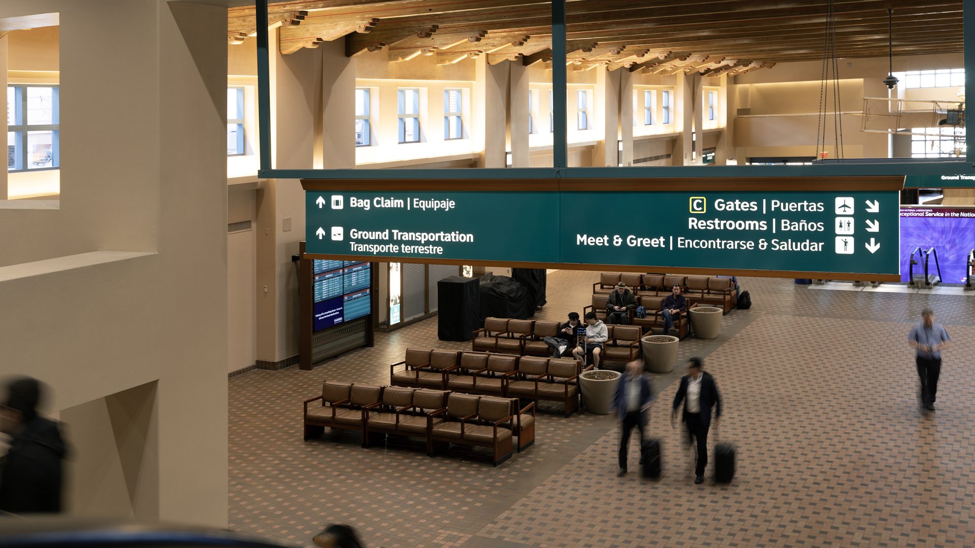 Illuminated hanging directional sign guiding passengers to gates and amenities