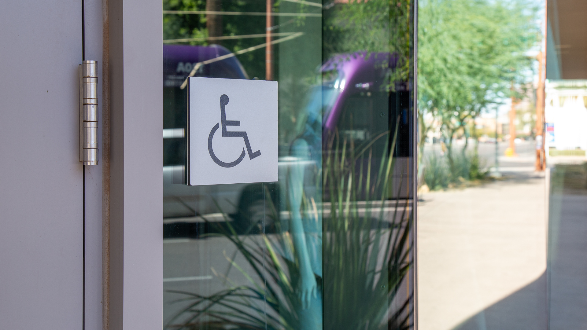Accessible entrance symbol on glass door at ASU Fusion on First indicating ADA-compliant entry