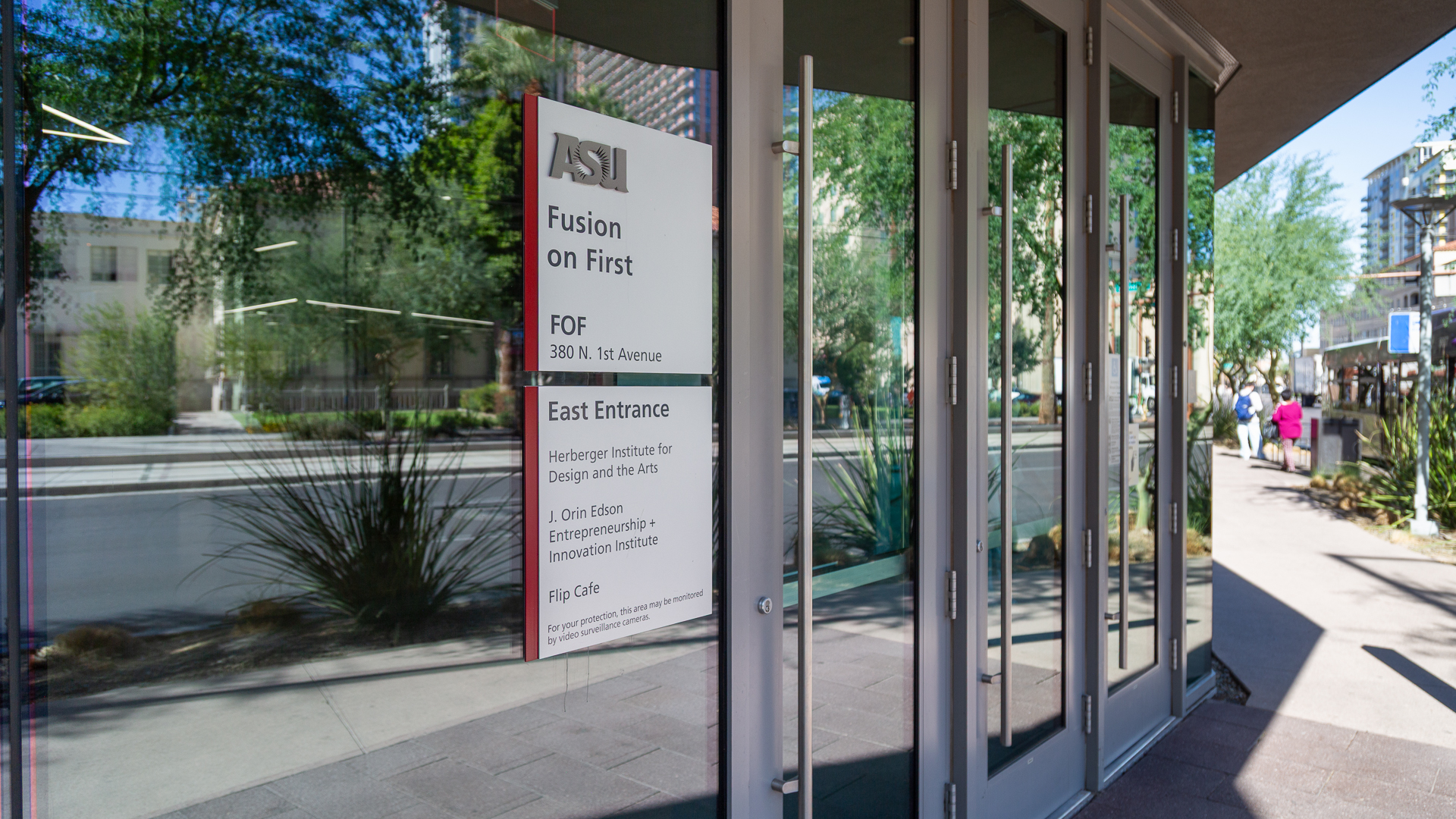 Close-up of ASU Fusion on First entry sign showing building name address and tenant directory on glass facade