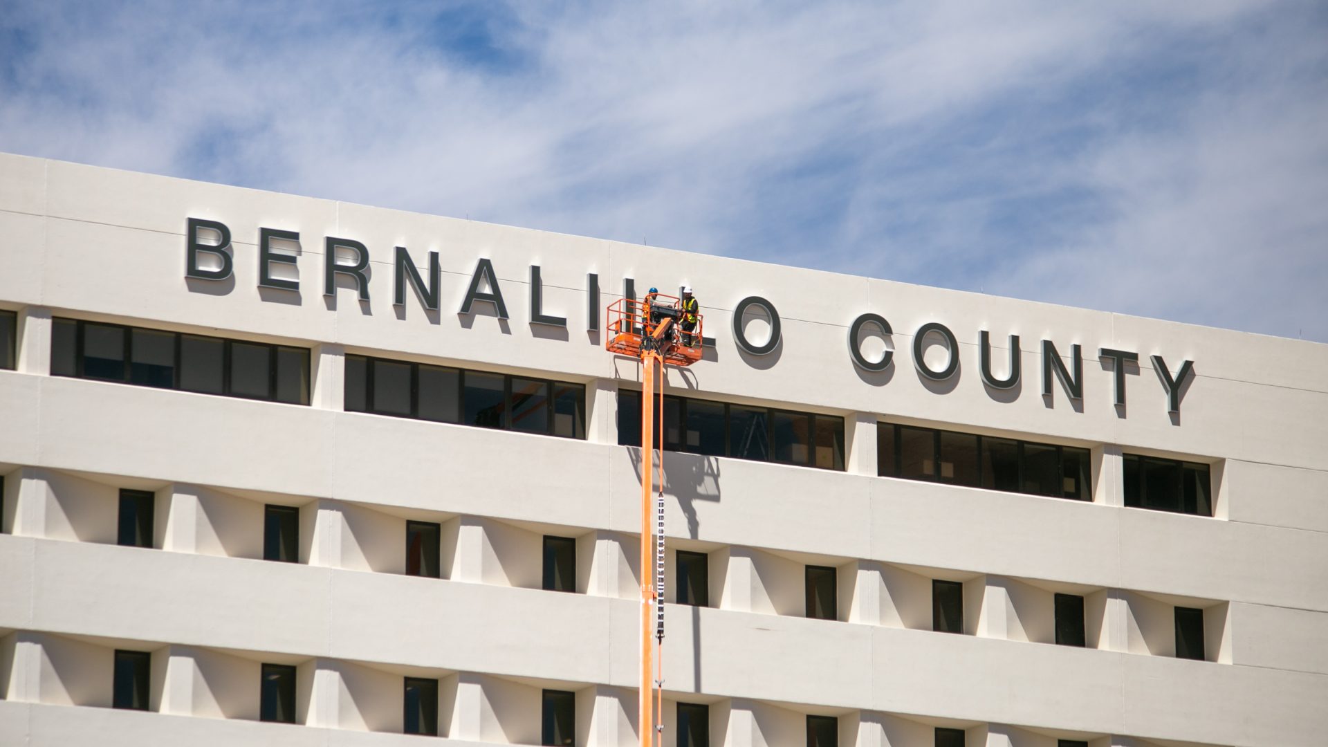 installation of large front lit channel letters on building facade using lift