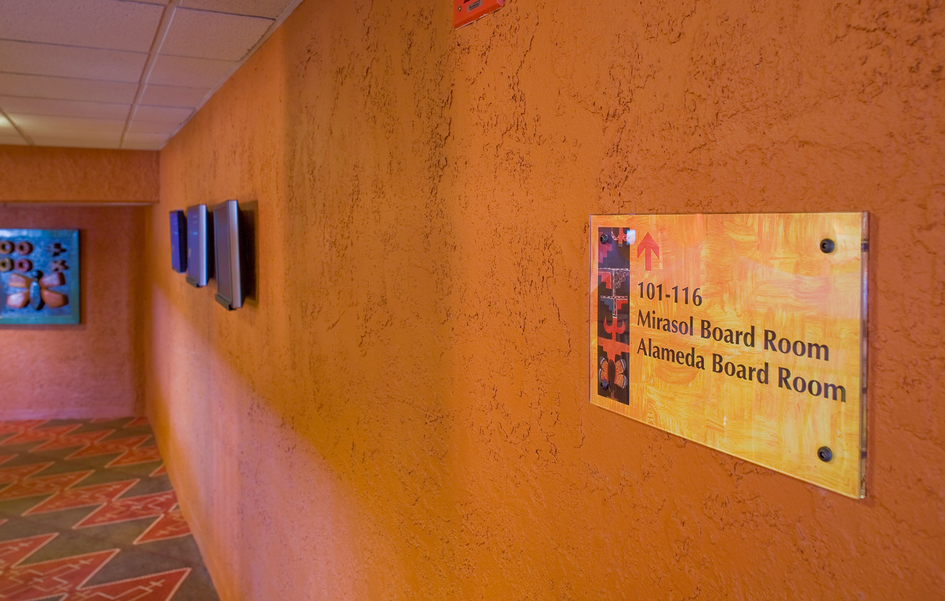 Interior hotel directional sign listing first floor amenities and services with custom graphics