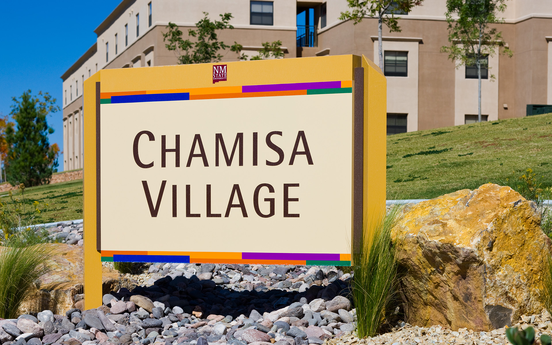 Large exterior monument sign identifying Chamisa Village student housing at New Mexico State University