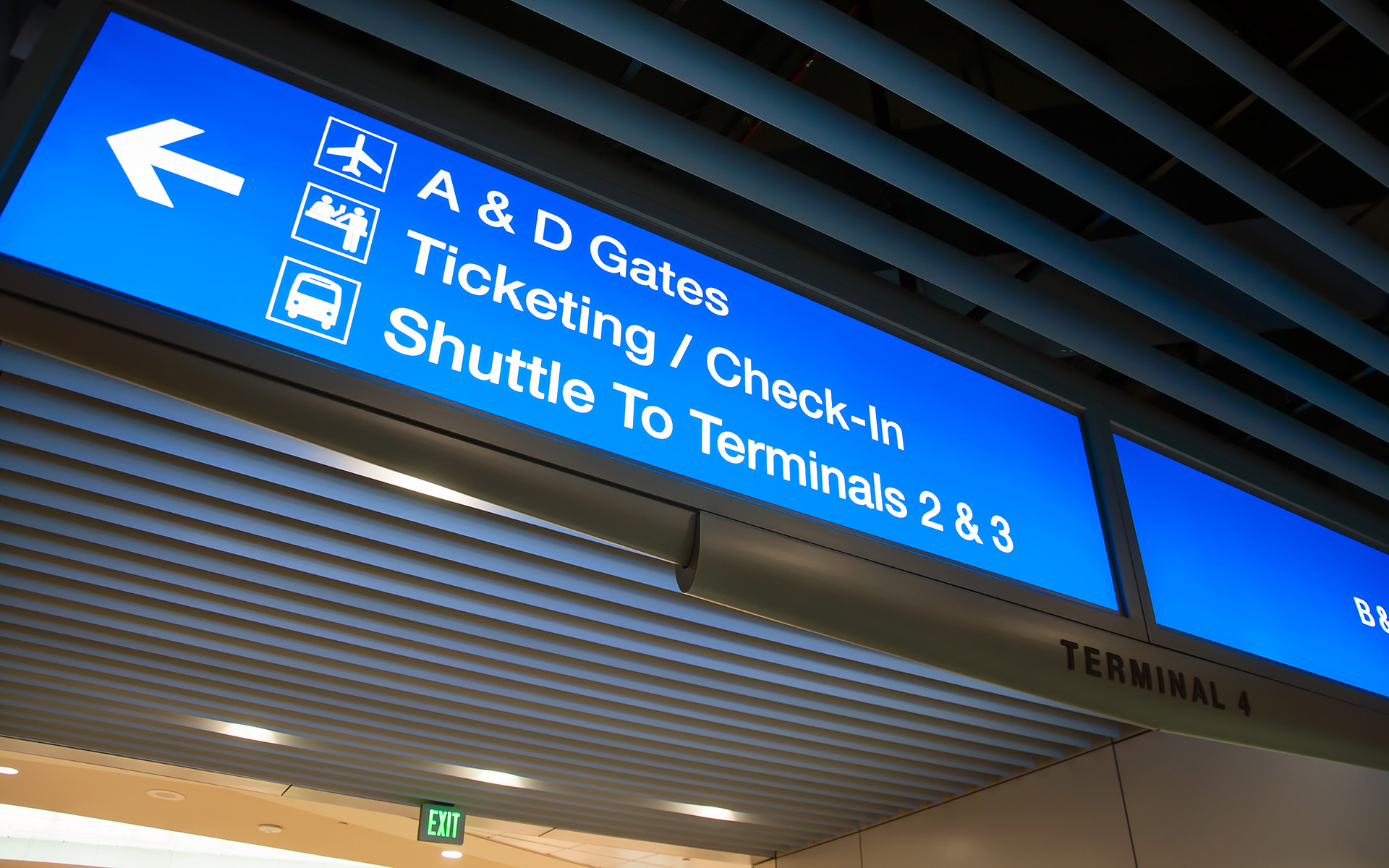 Illuminated airport signage directing to gates terminals and transit connections at PHX Sky Train station