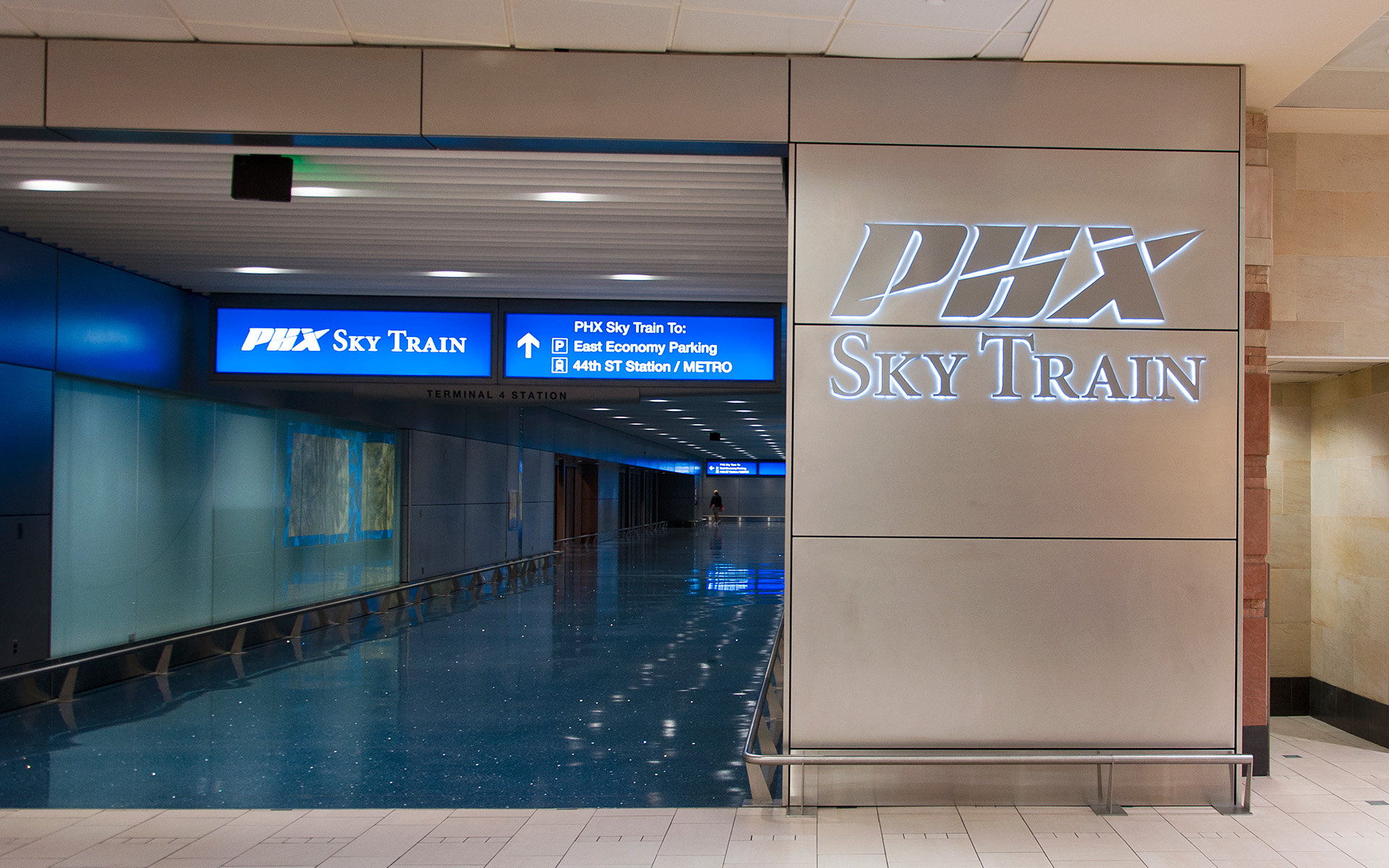 Halo illuminated stainless steel channel letters identifying PHX Sky Train at Terminal 4