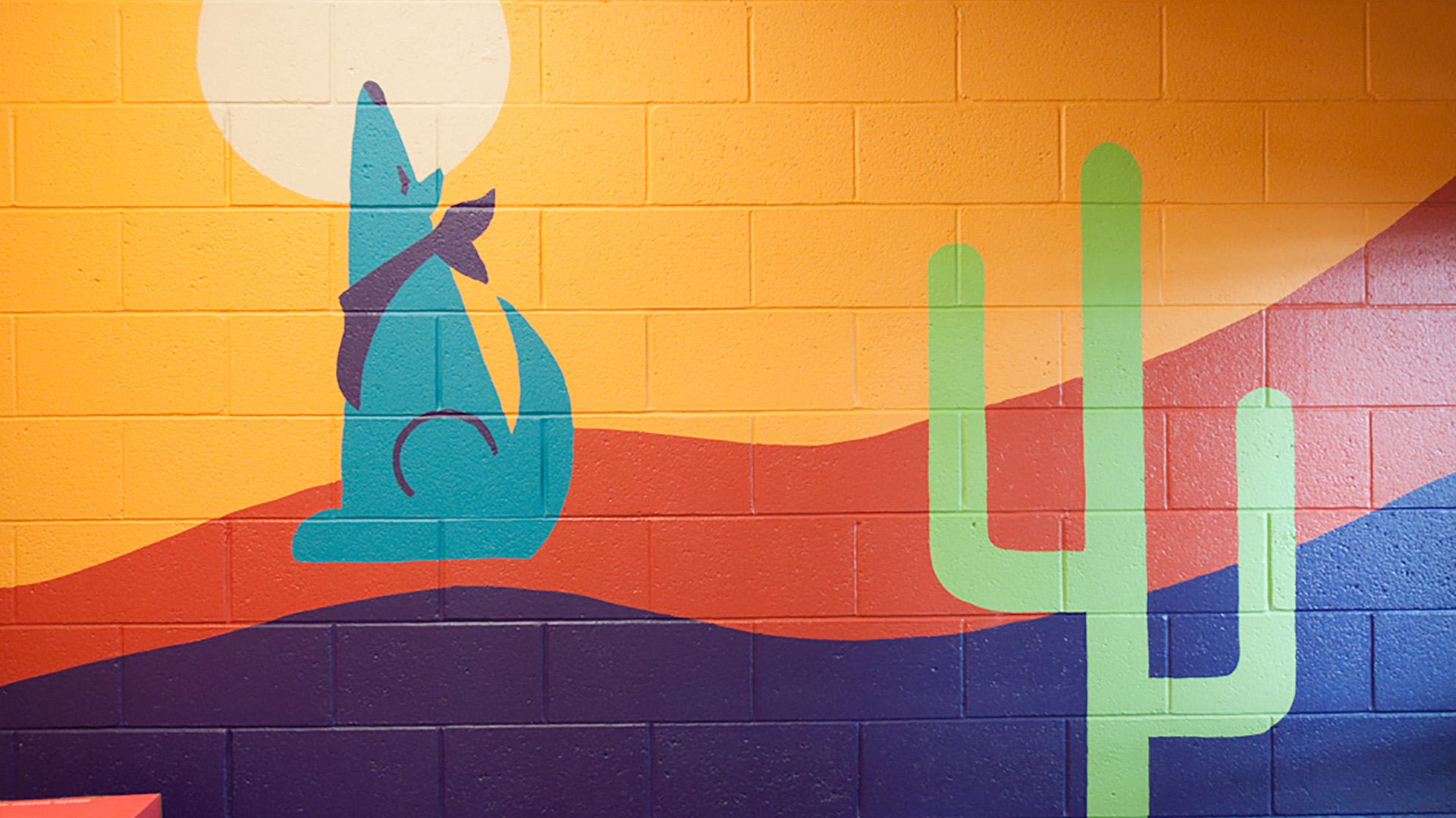 Colorful desert themed mural painted on CMU wall