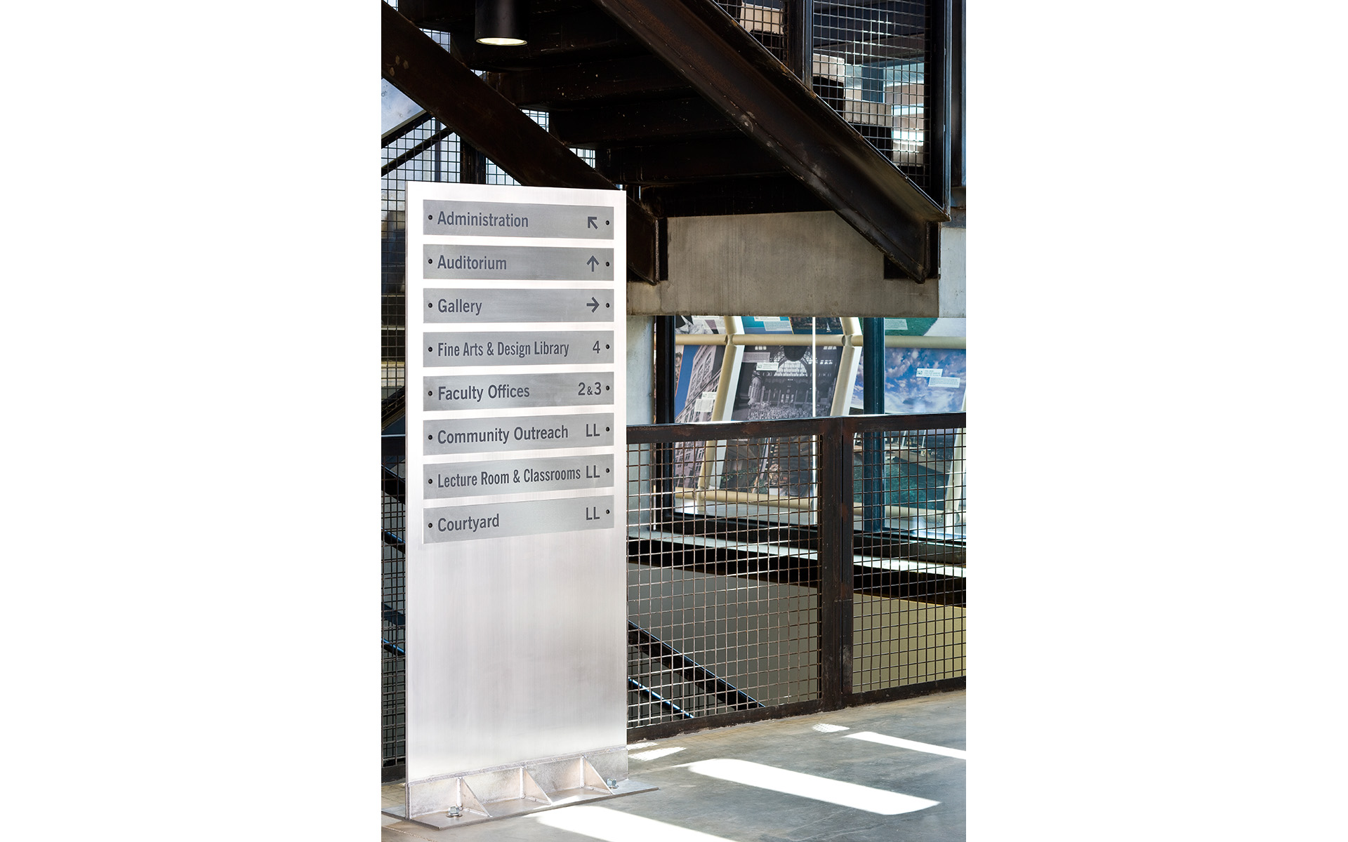 Interior freestanding wayfinding sign showing directions to administration, classrooms, and facilities