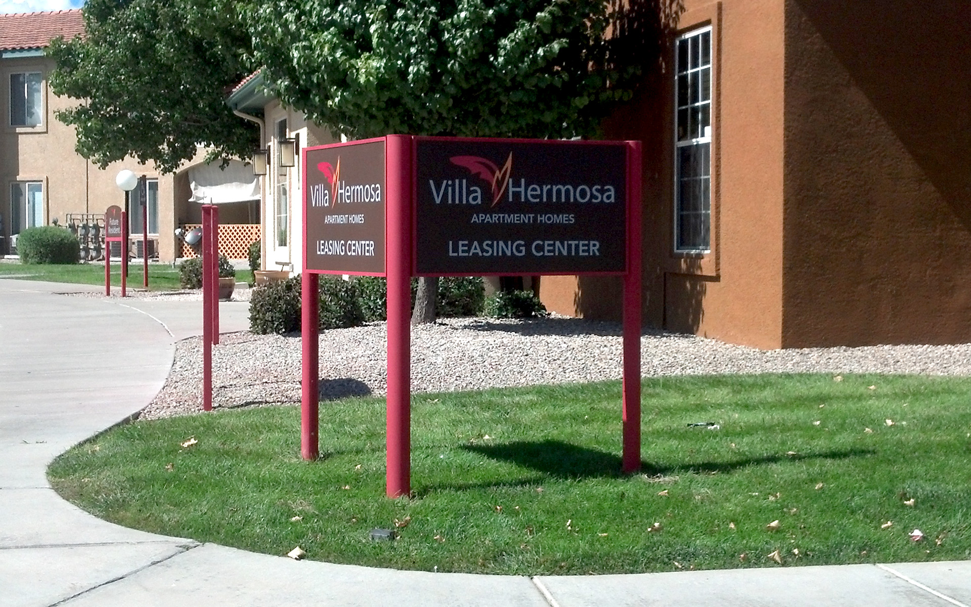 Apartment community leasing center monument sign with branded panel and directional messaging