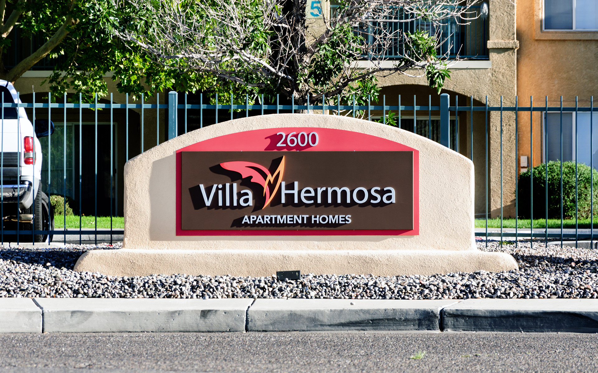 Monument sign integrated with architectural base displaying address number and branding