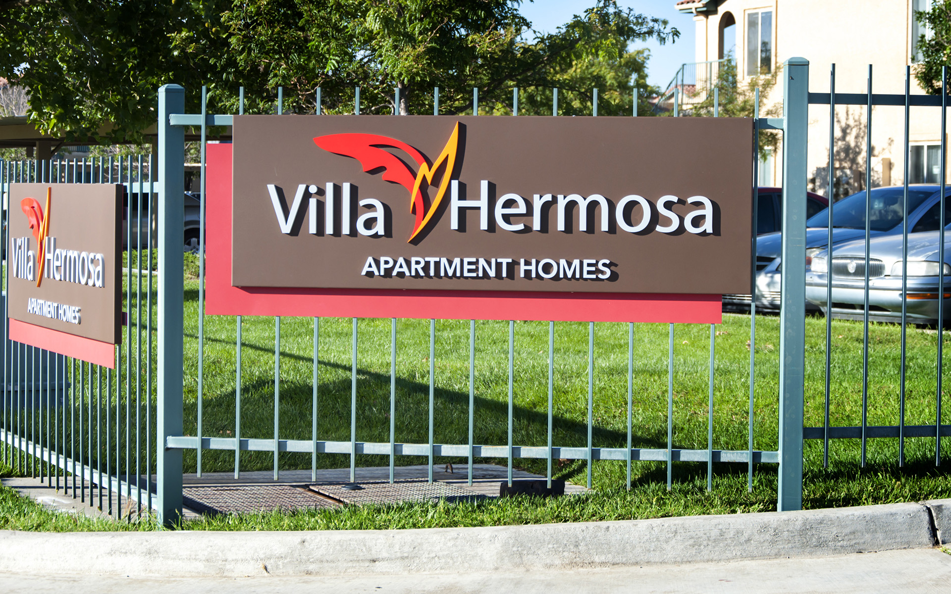 Angled view of apartment monument sign showing depth and layered panel design