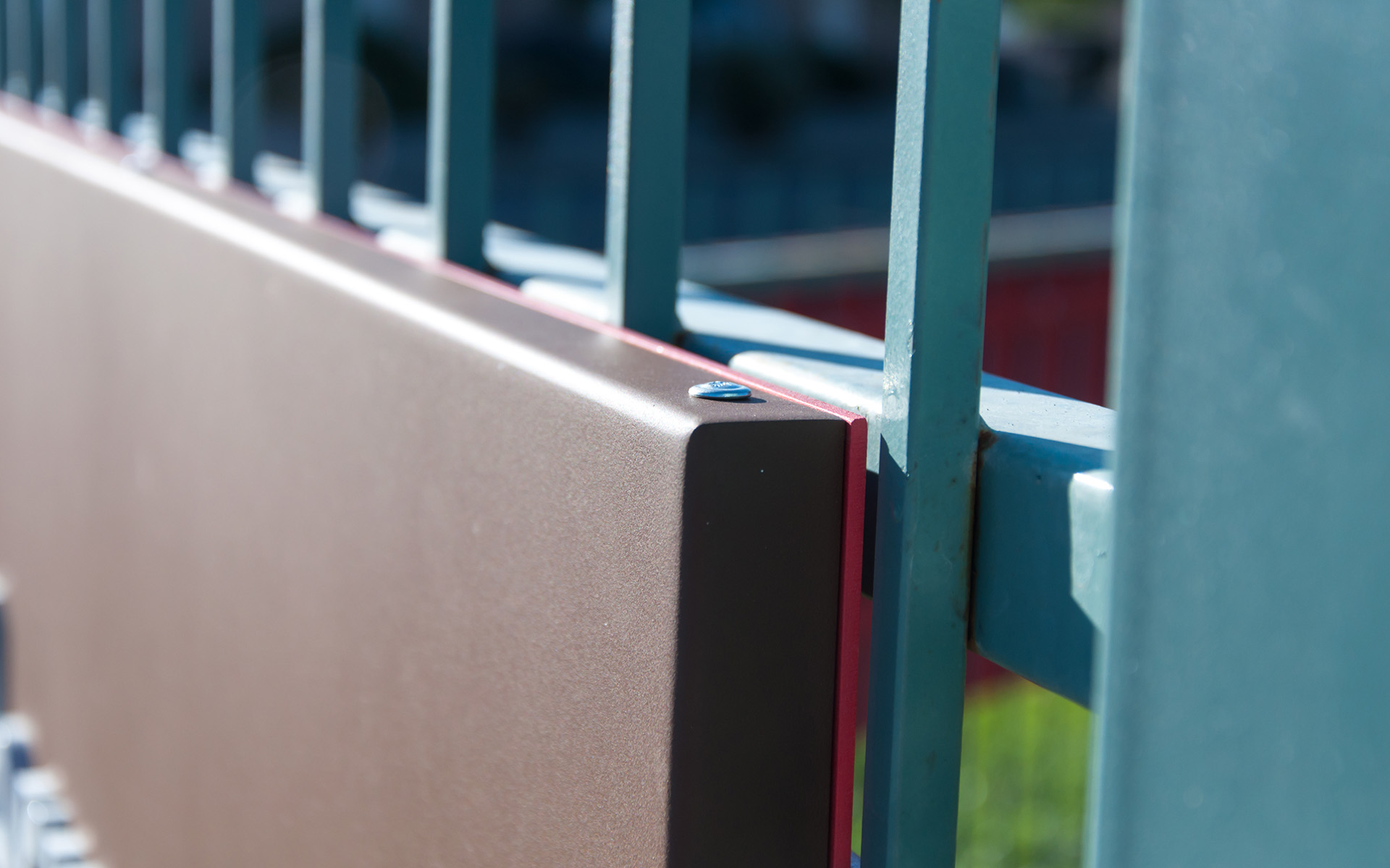 Monument sign mounted directly to metal fence with integrated support structure