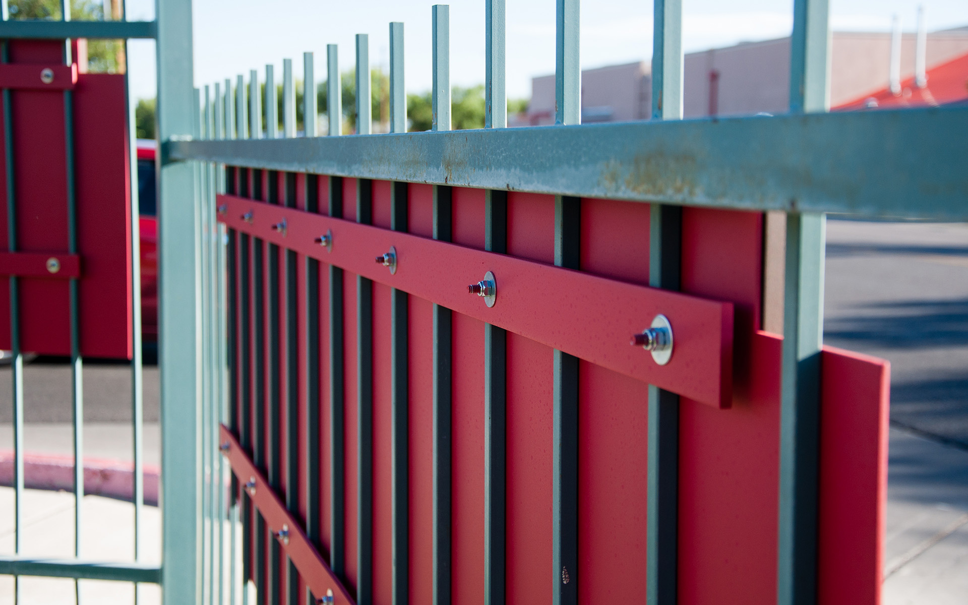 Close-up of monument sign mounting hardware and panel attachment to metal fence