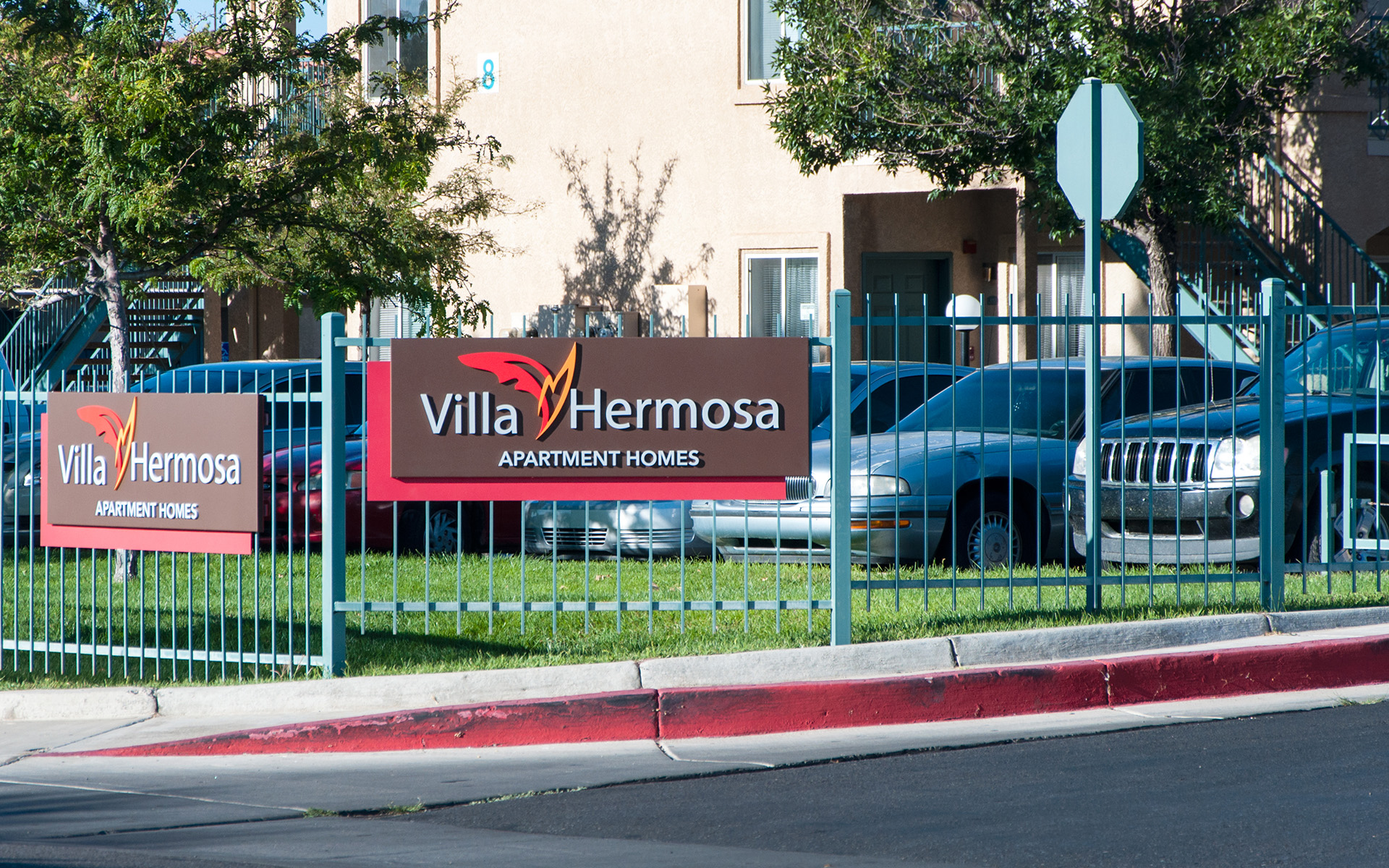 Street view of apartment monument sign showing visibility from roadway and traffic approach