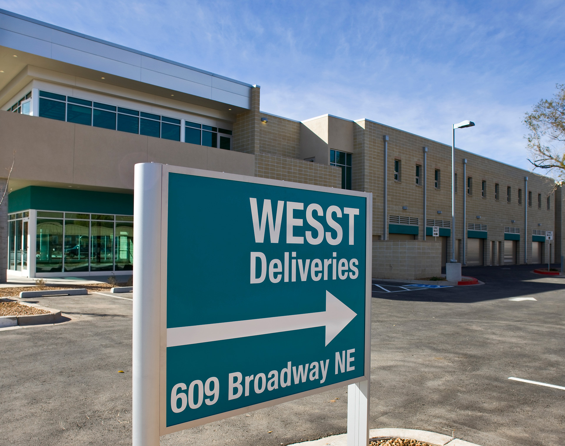 Exterior directional post and panel sign reading WESST deliveries with address