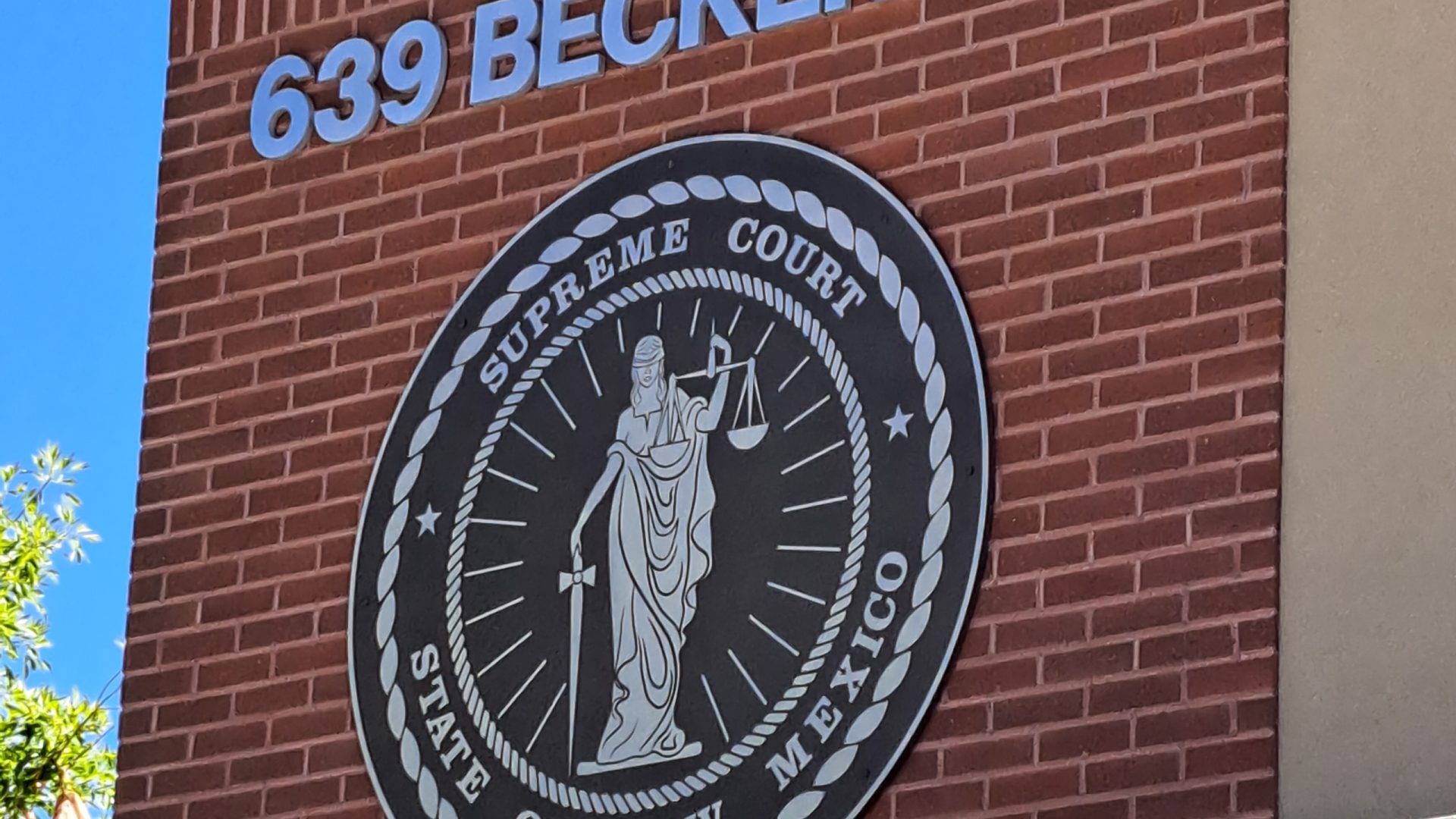 Close-up of a 60 inch cast aluminum Supreme Court of New Mexico seal plaque with raised brushed aluminum graphics and Duranodic Bronze background