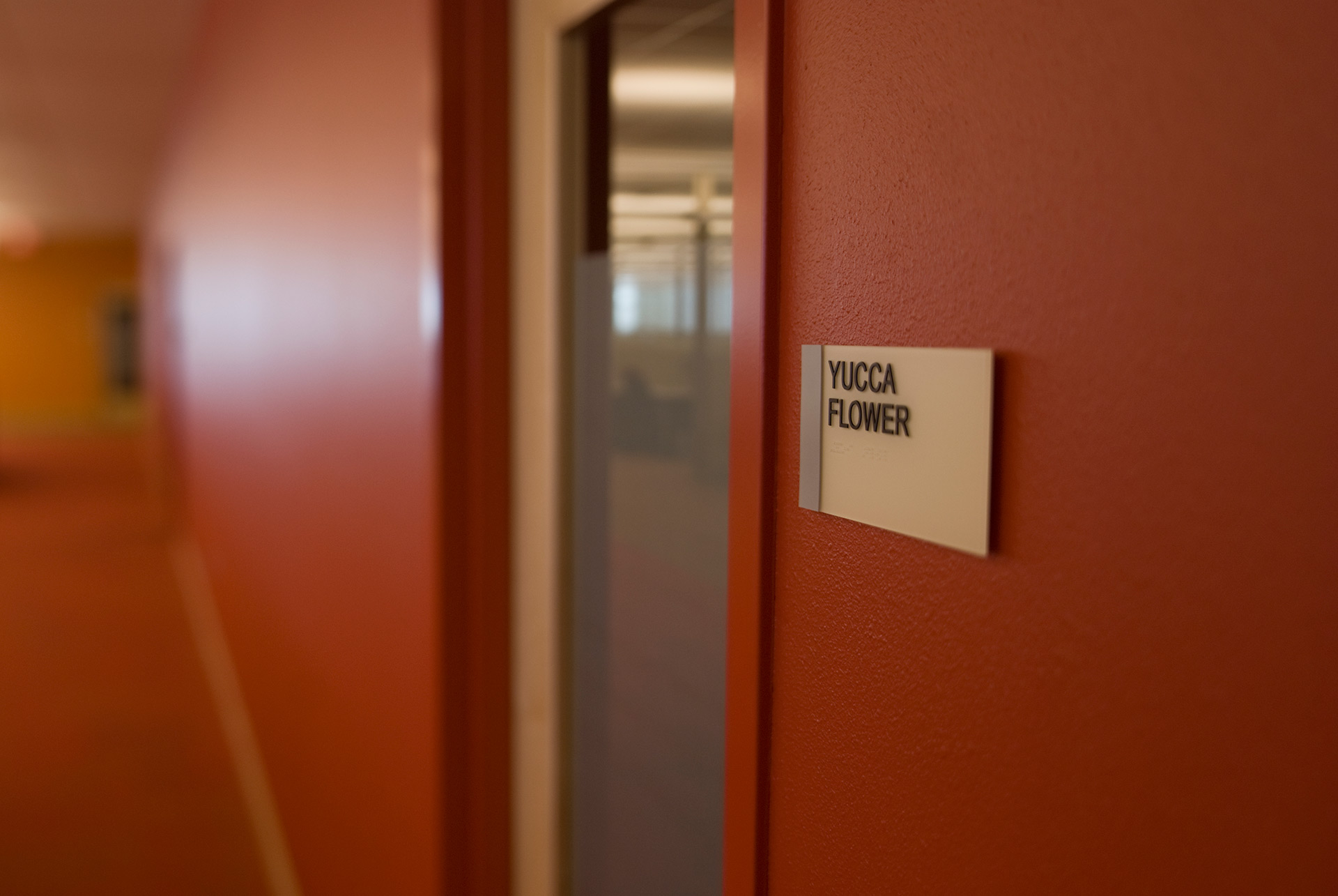 Wall mounted ADA room identification sign with braille and tactile text