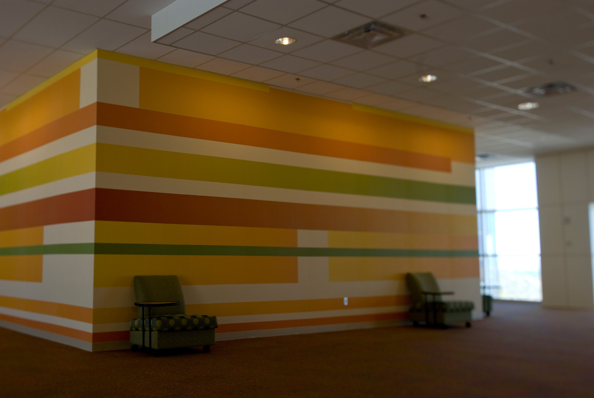 Colorful horizontal striped wall graphics in corporate office interior branding environment