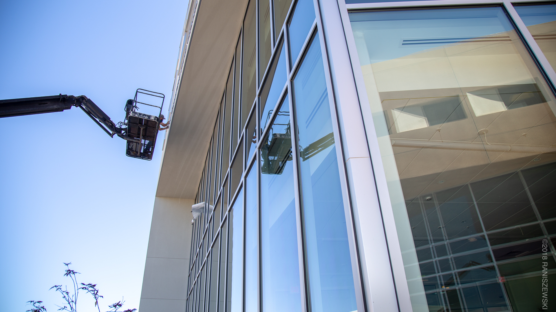 Installer on boom truck installing architectural letters on exterior building