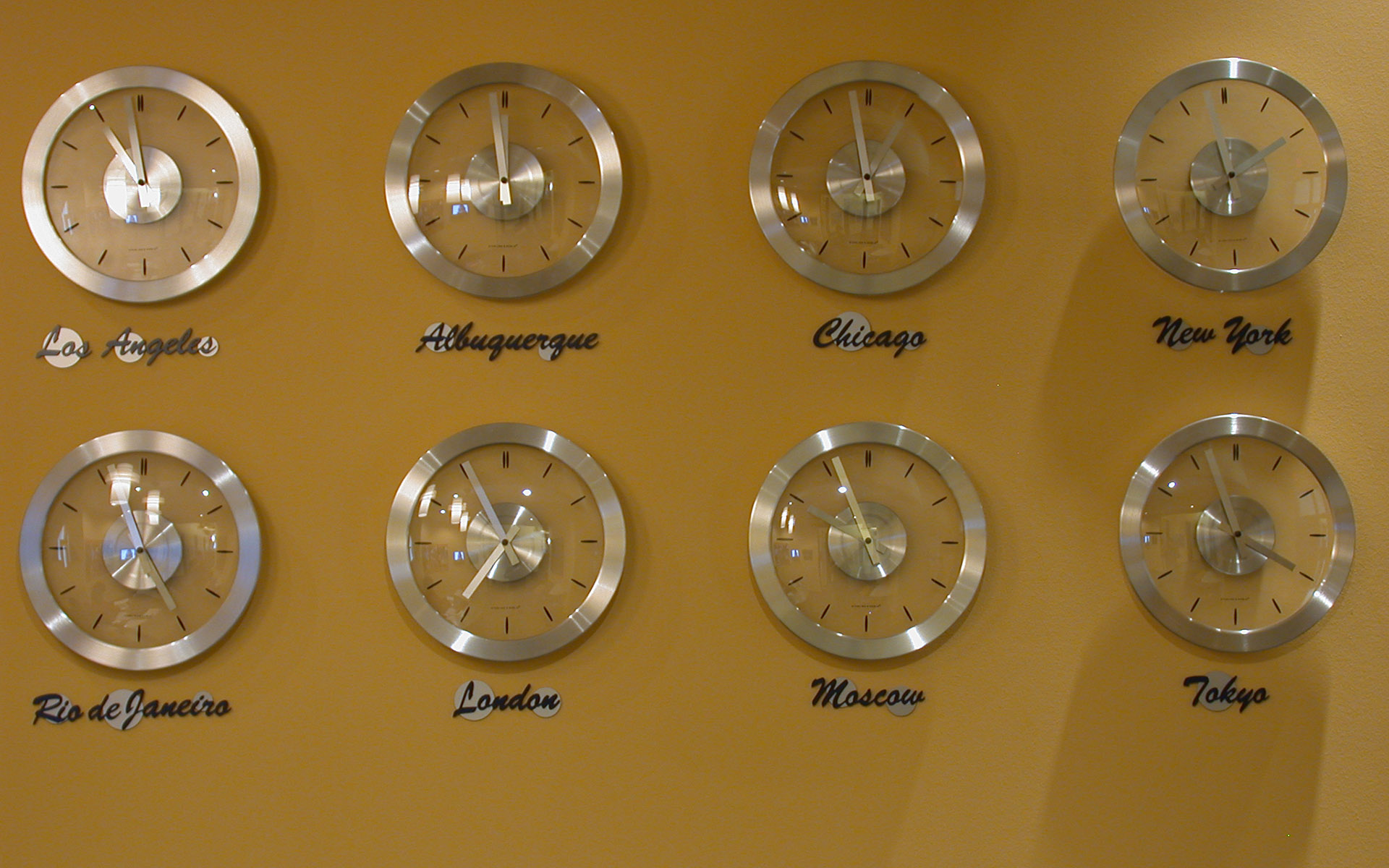 Wall clocks with custom dimensional city name lettering for a commercial interior.