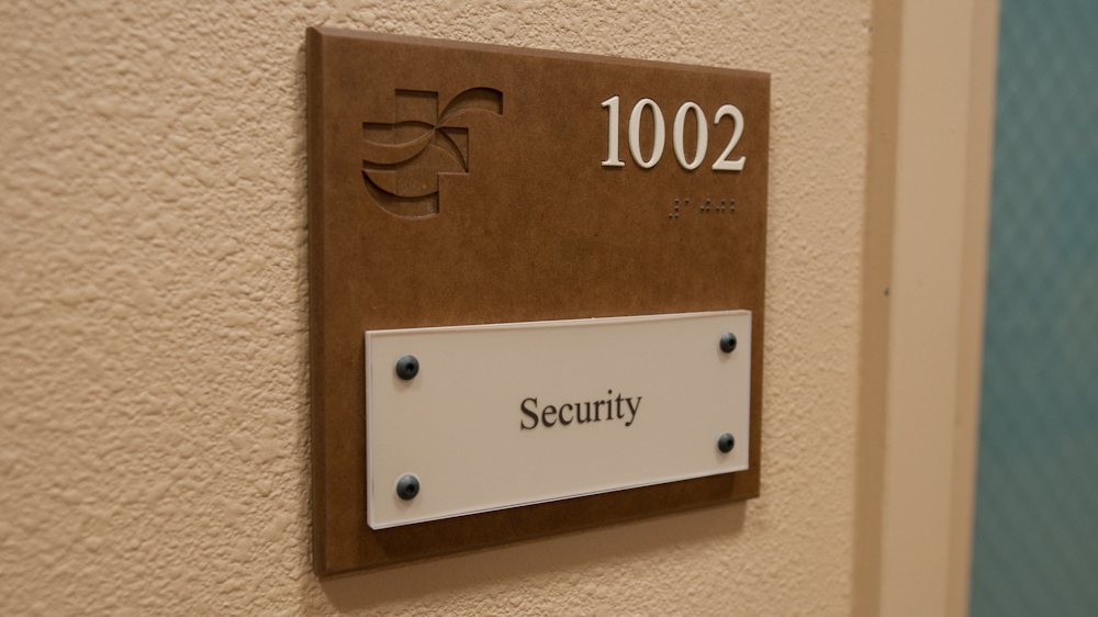 ADA room identification sign with bolt-n-place updateable insert and engraved logo at Christus St. Vincent Regional Medical Center