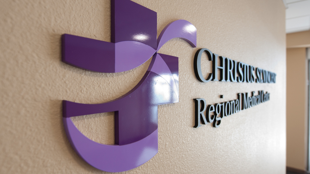 Dimensional healthcare logo and aluminum lettering mounted to textured interior wall
