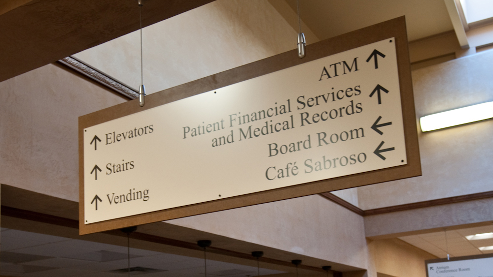 Overhead suspended directional sign from the CSB Texture Sign System at Christus St. Vincent Regional Medical Center
