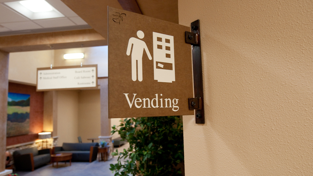 Projecting vending area identification sign with pictogram and textured finish