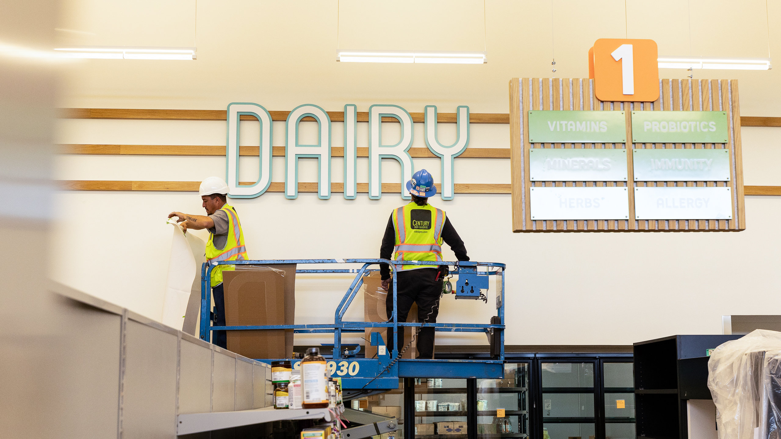 Installation of dimensional dairy department lettering and suspended aisle signage at La Montañita Food Co-op
