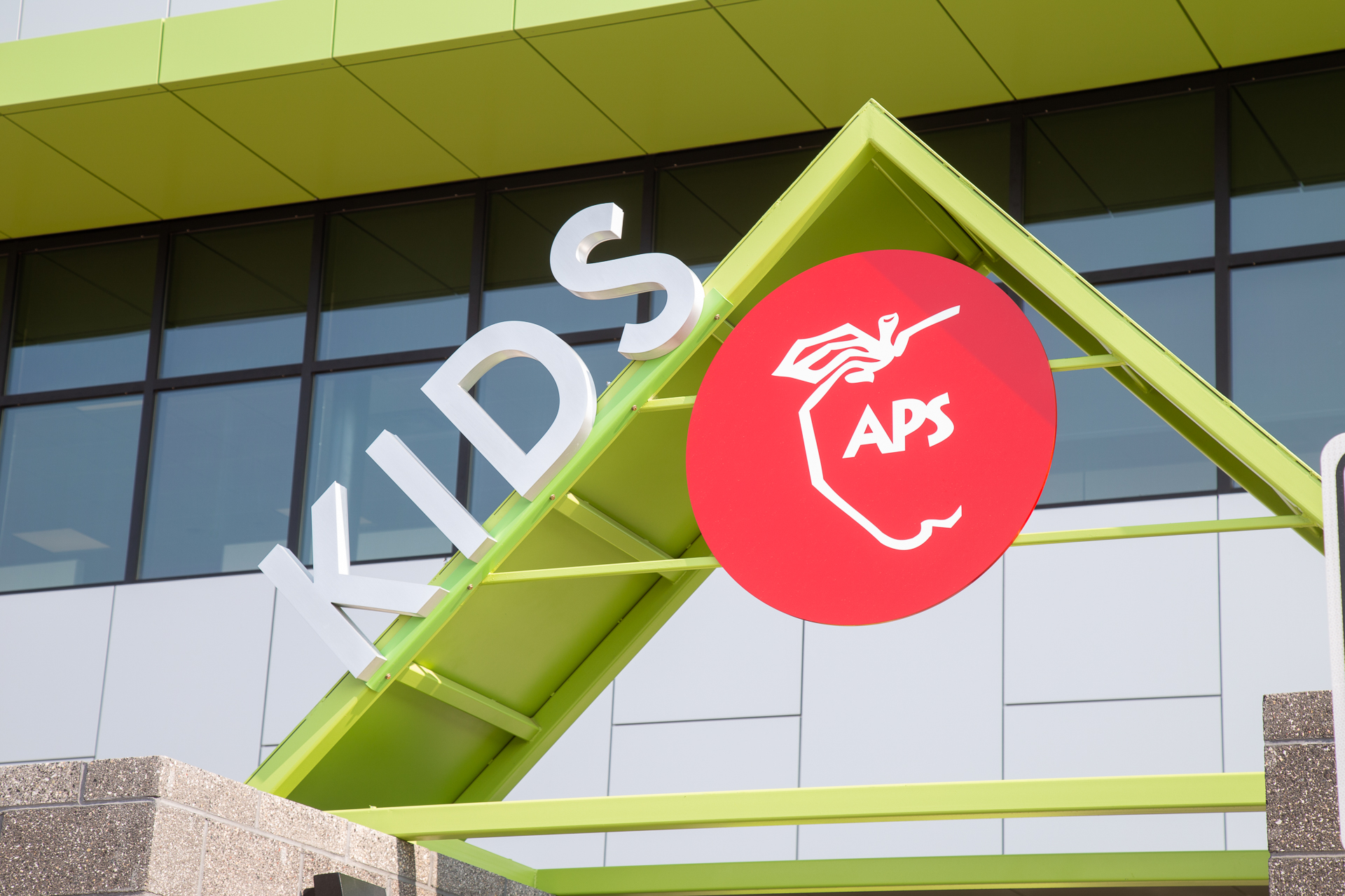APS-Architectural-Letters-Kids Fabricated metal logo with brushed finish mounted in corporate office environment at Caliente Construction Phoenix Arizona