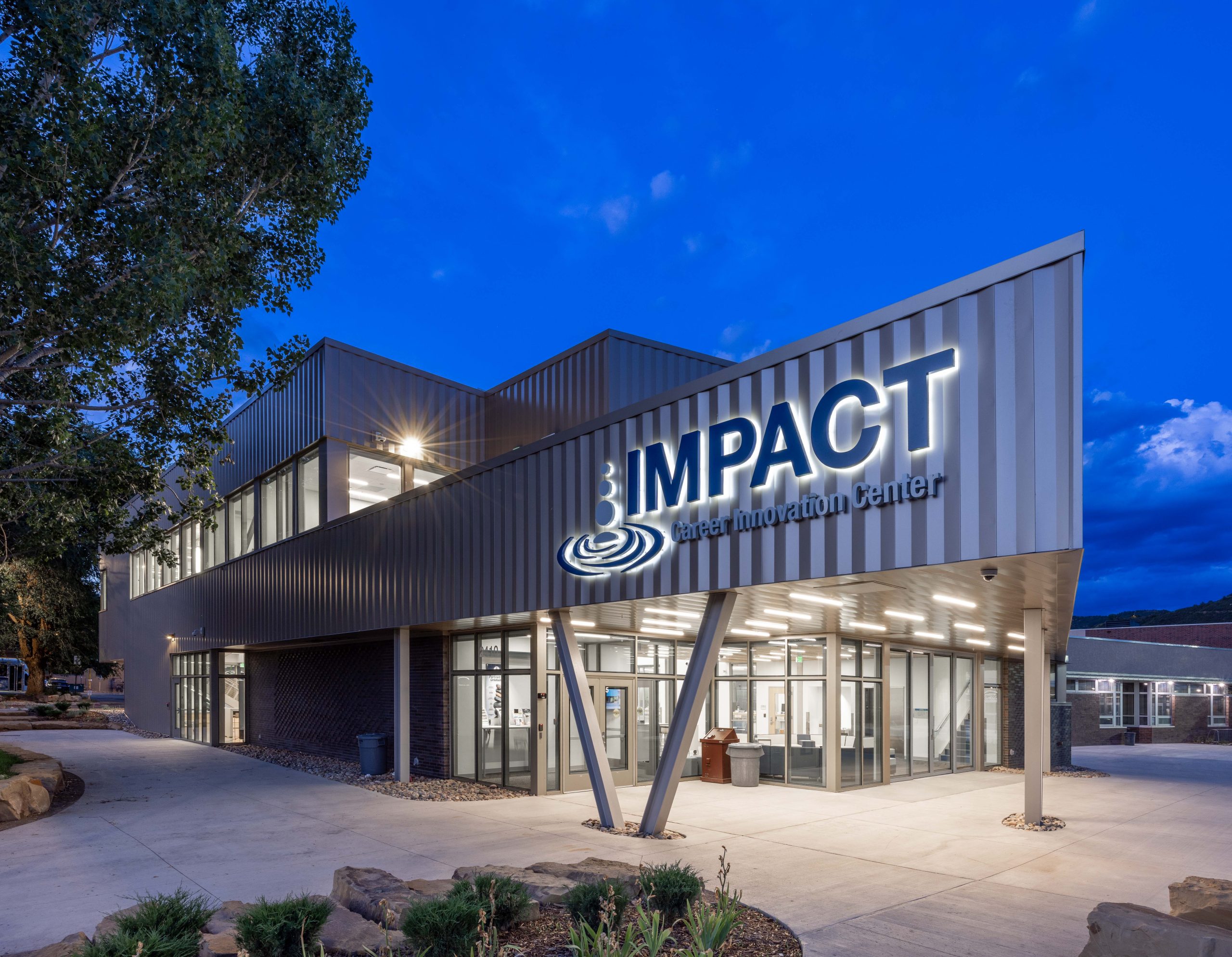 Durango-IMPACT-Center-Halo-Lit Updateable wow wall display at Caliente Construction front desk featuring interchangeable room signage panel in branded office environment