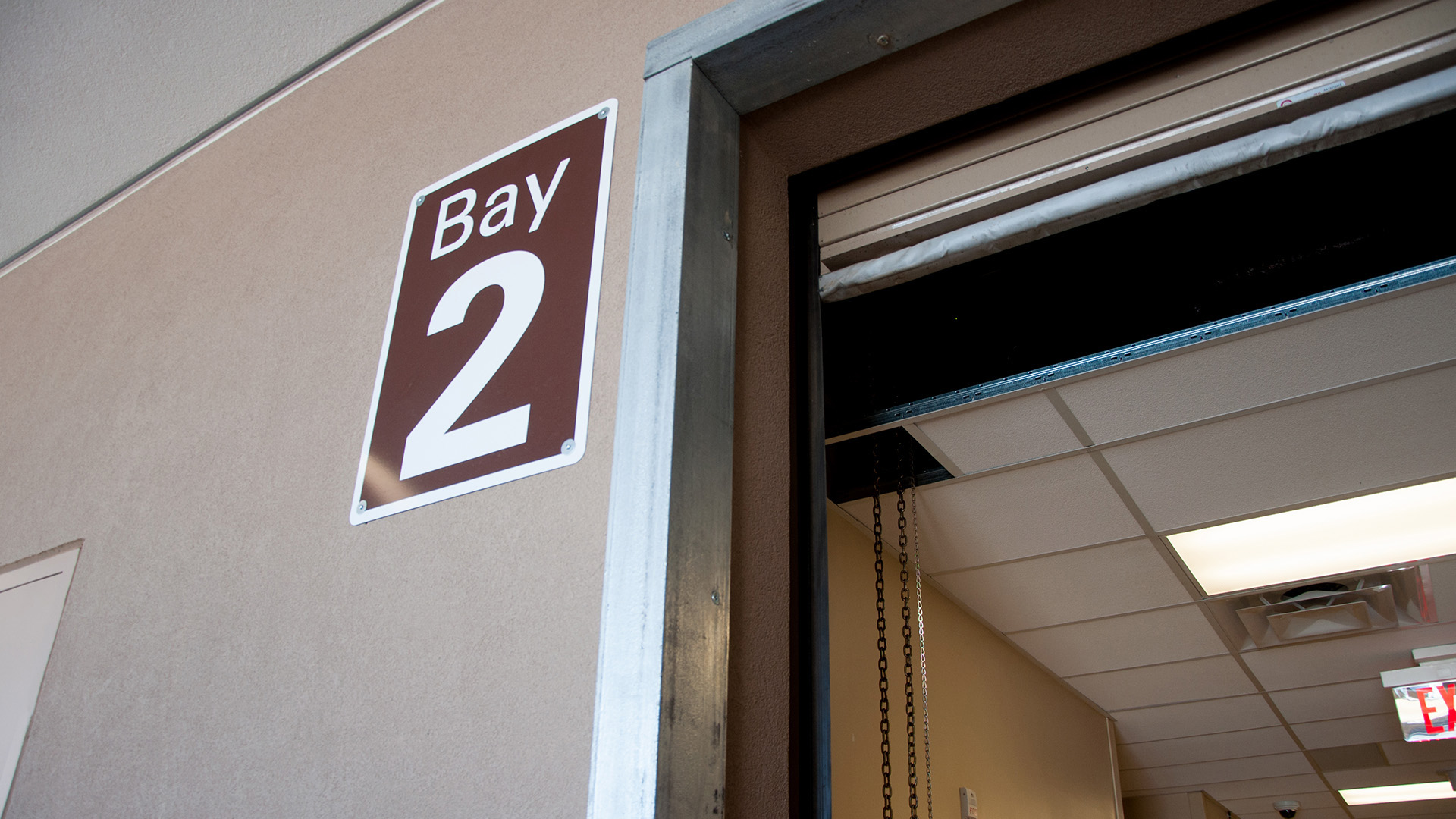 Wall-mounted aluminum delivery bay sign at UNM Sandoval Regional Medical Center