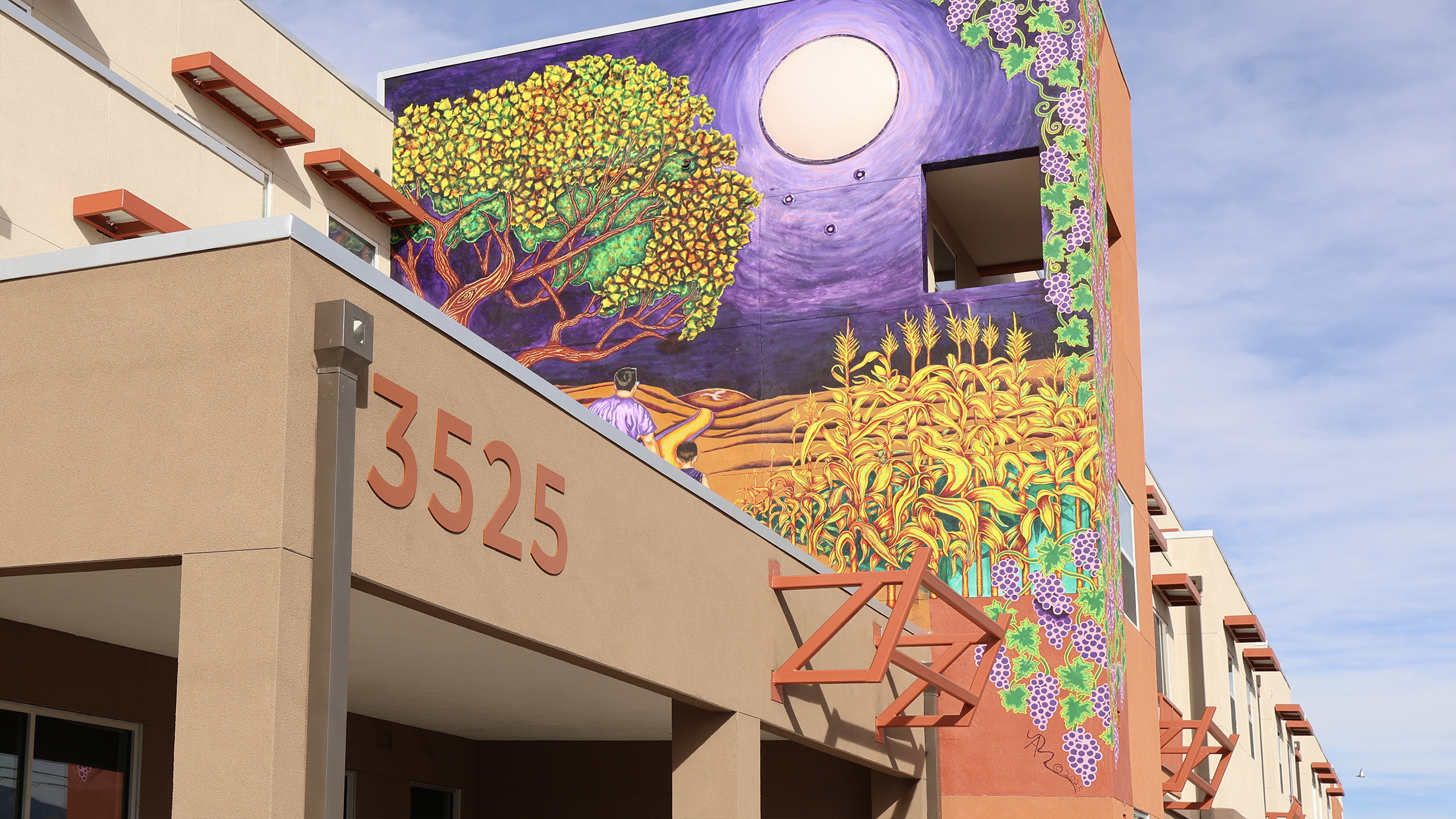 Flat cut aluminum address numbers mounted on the exterior of Calle Cuarta Apartments in Albuquerque, New Mexico.